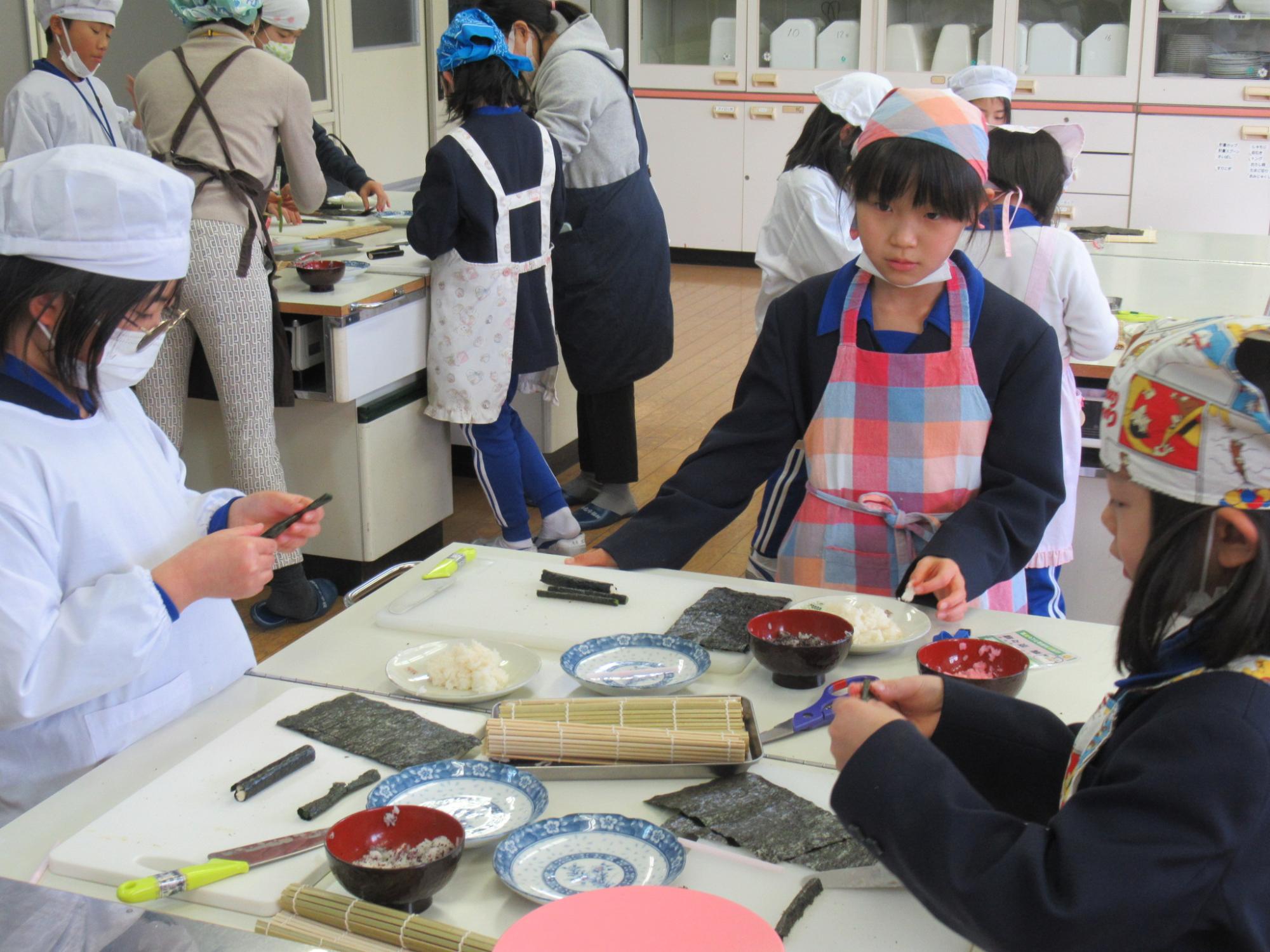 参加者が野沢菜や魚肉ソーセージに巻くのりで、顔のパーツを再現しようとしている写真