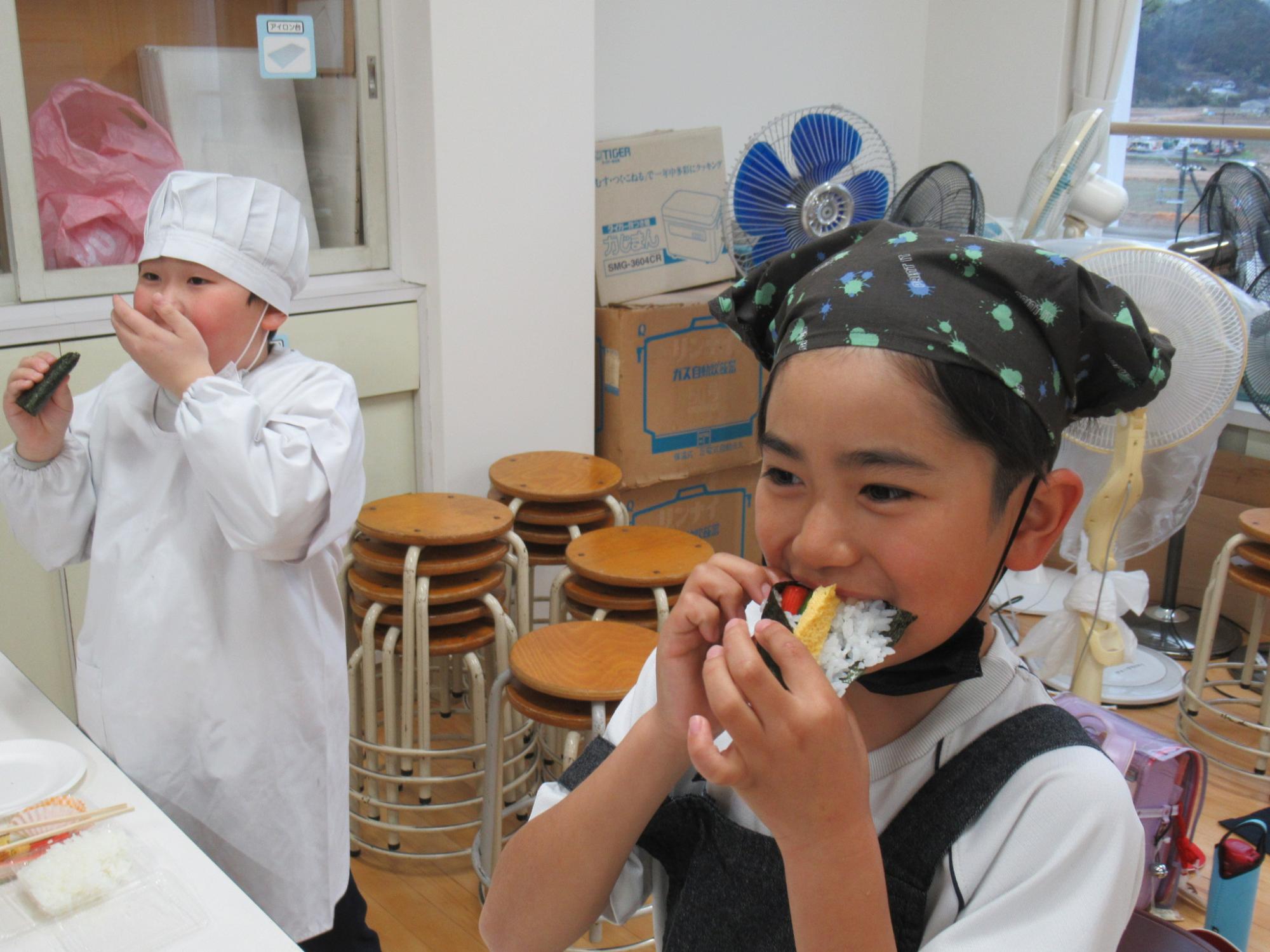 作りたての巻き寿司を参加者が頬張っている写真