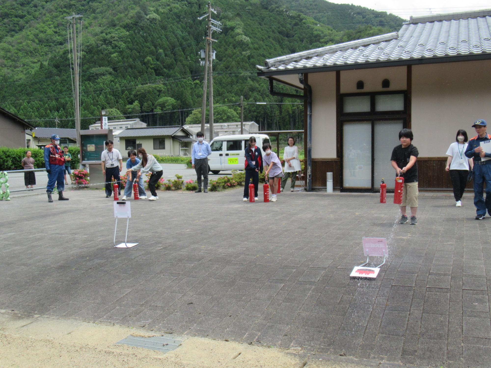 参加者が水消火器で的当てに挑戦している写真