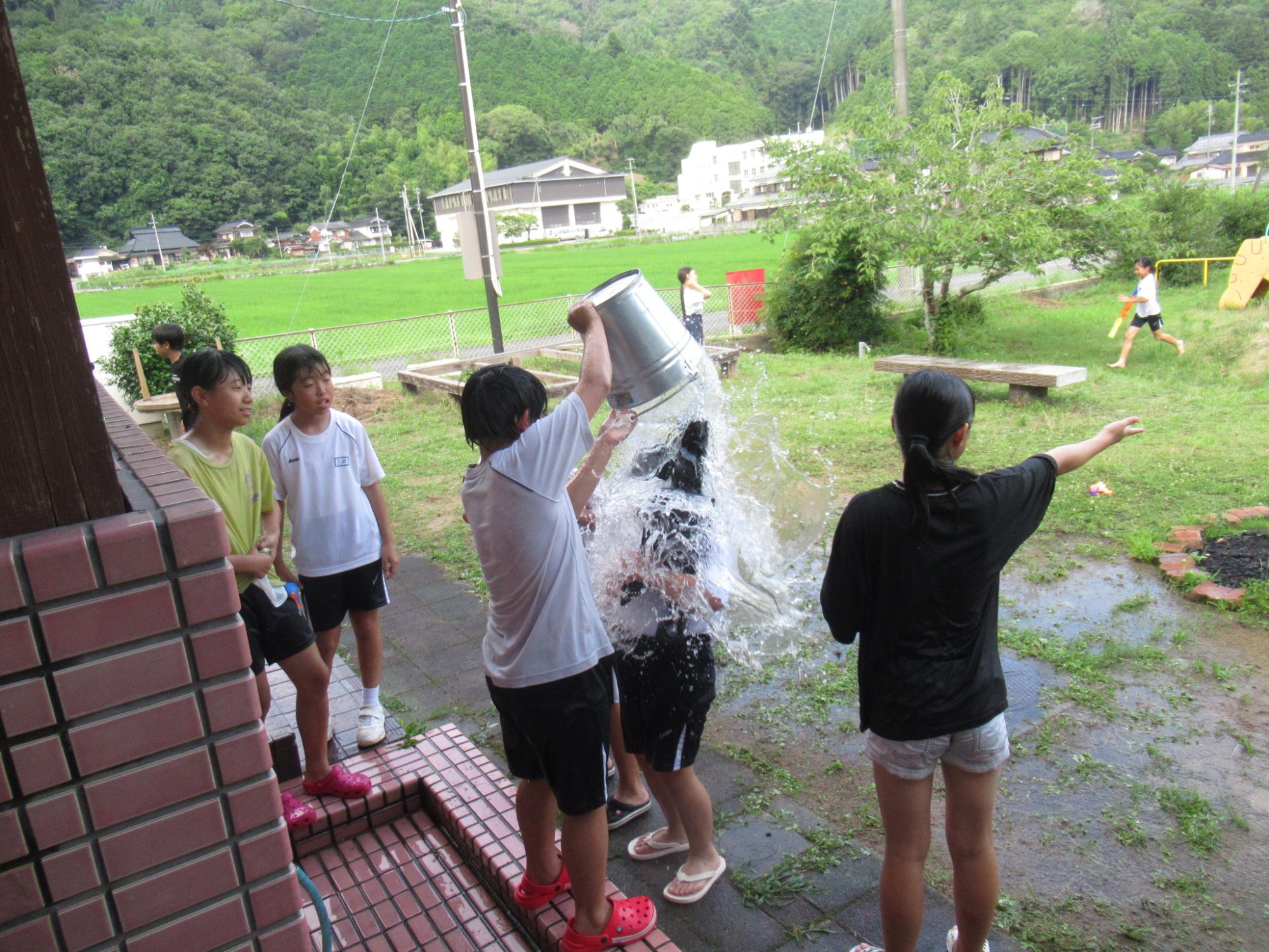 バケツいっぱいの水を子どもが被っている写真