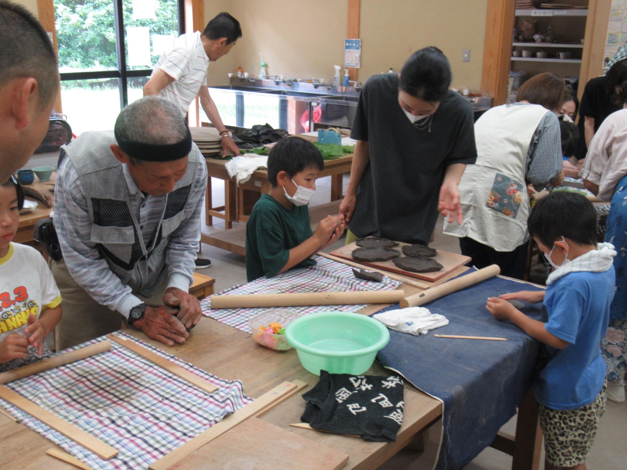 陶芸団体の方から作り方を教わりながらお皿づくりに挑戦する子どもたち