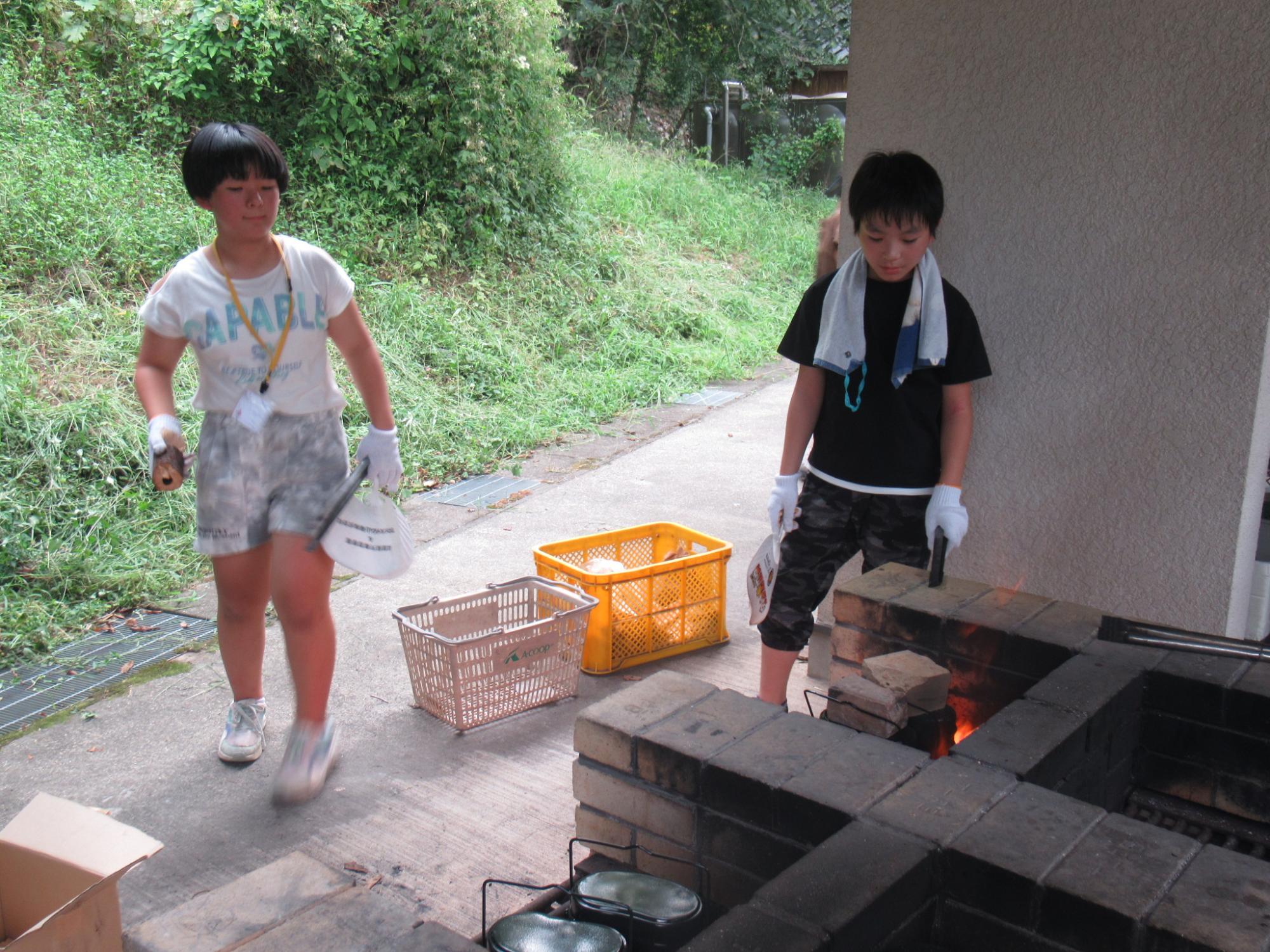 参加者が火を起こして飯ごう炊さんに挑戦している写真