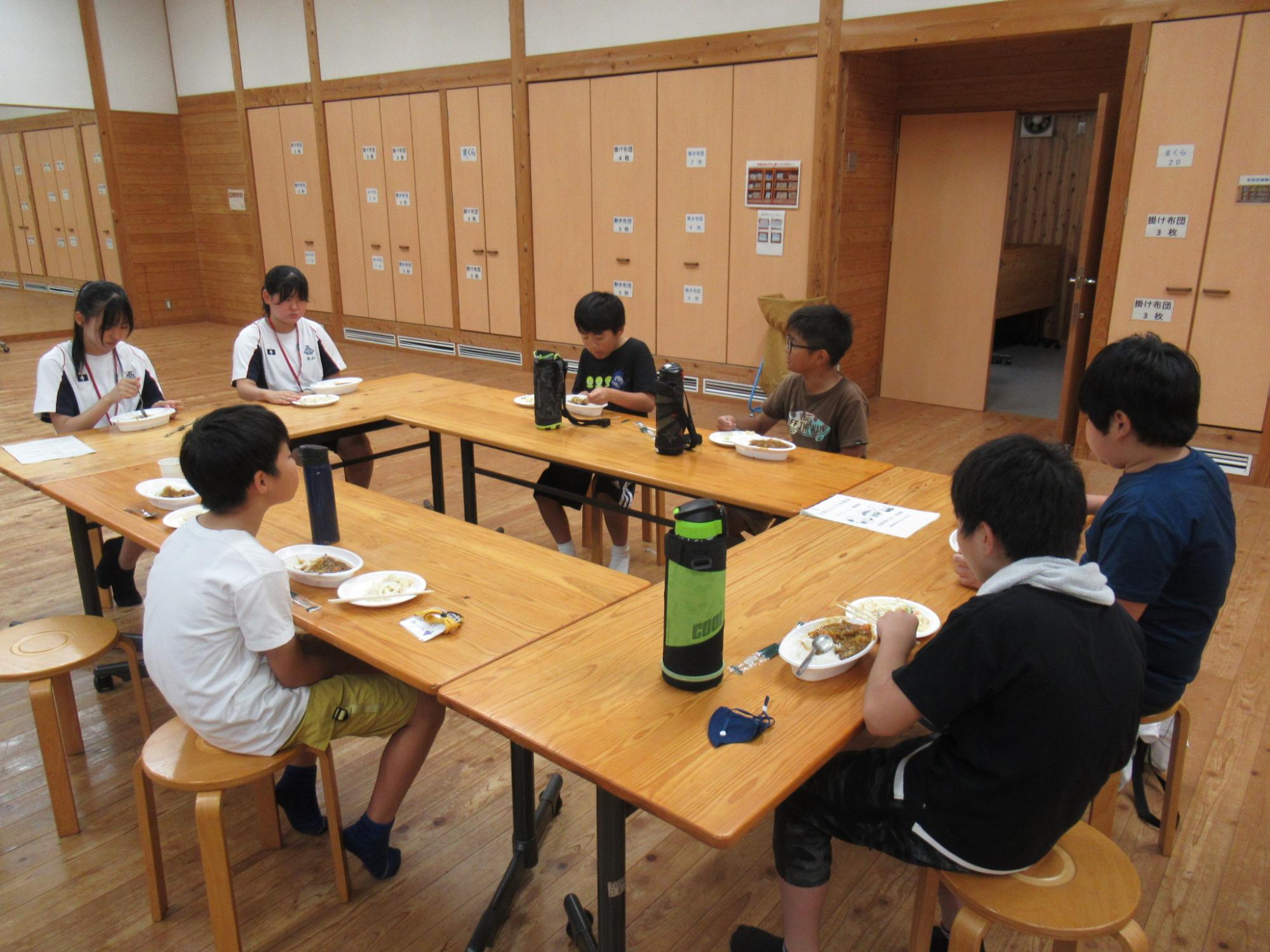 皆で作ったカレーを一緒に食べる参加者たち