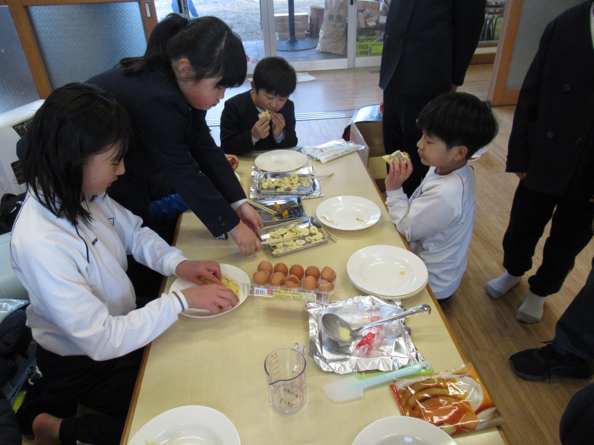 参加者が自分たちで作ったクレープ生地に具材をトッピングして食べている写真
