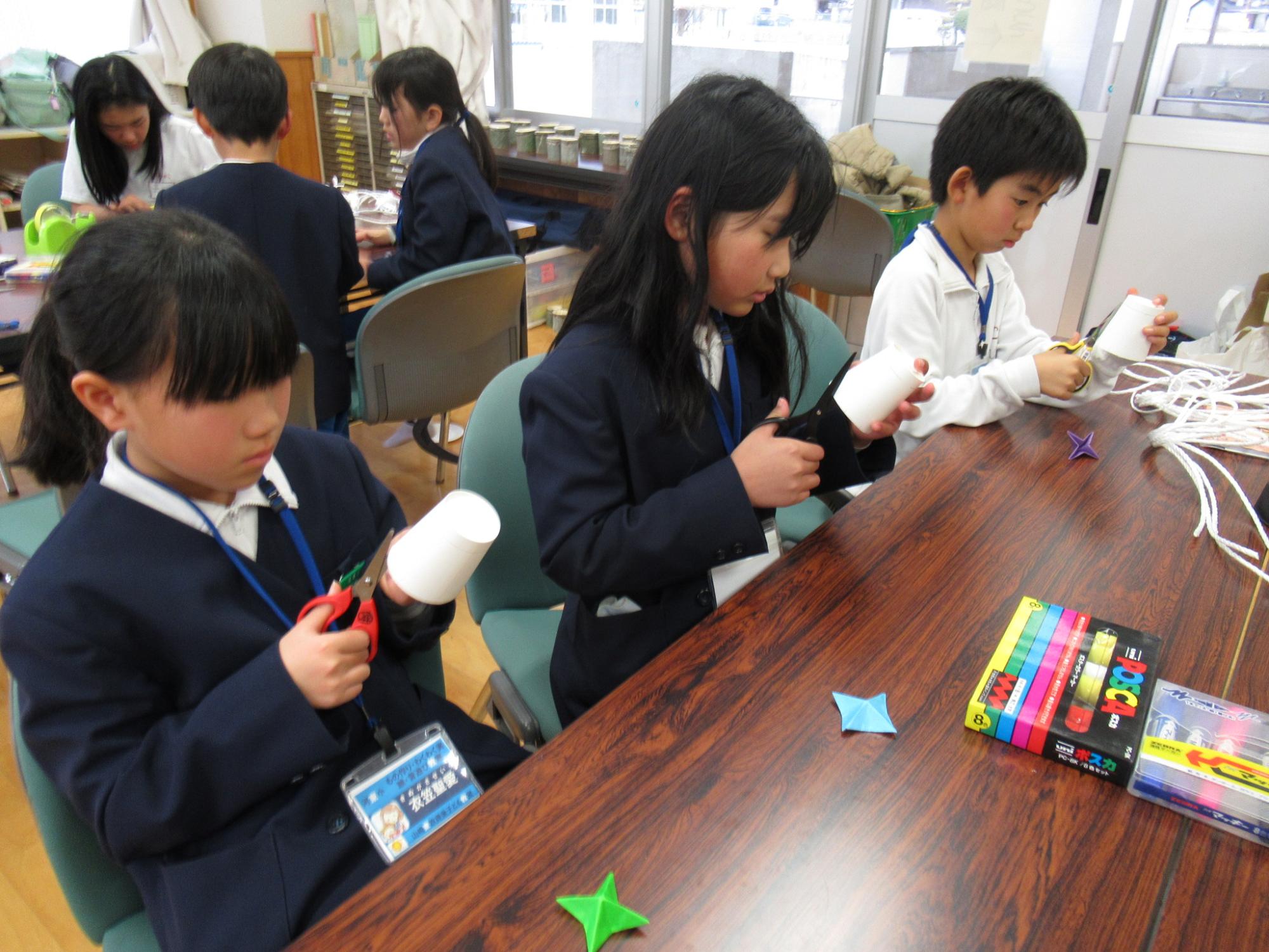 参加者が材料の紙コップをハサミで切り分けている写真