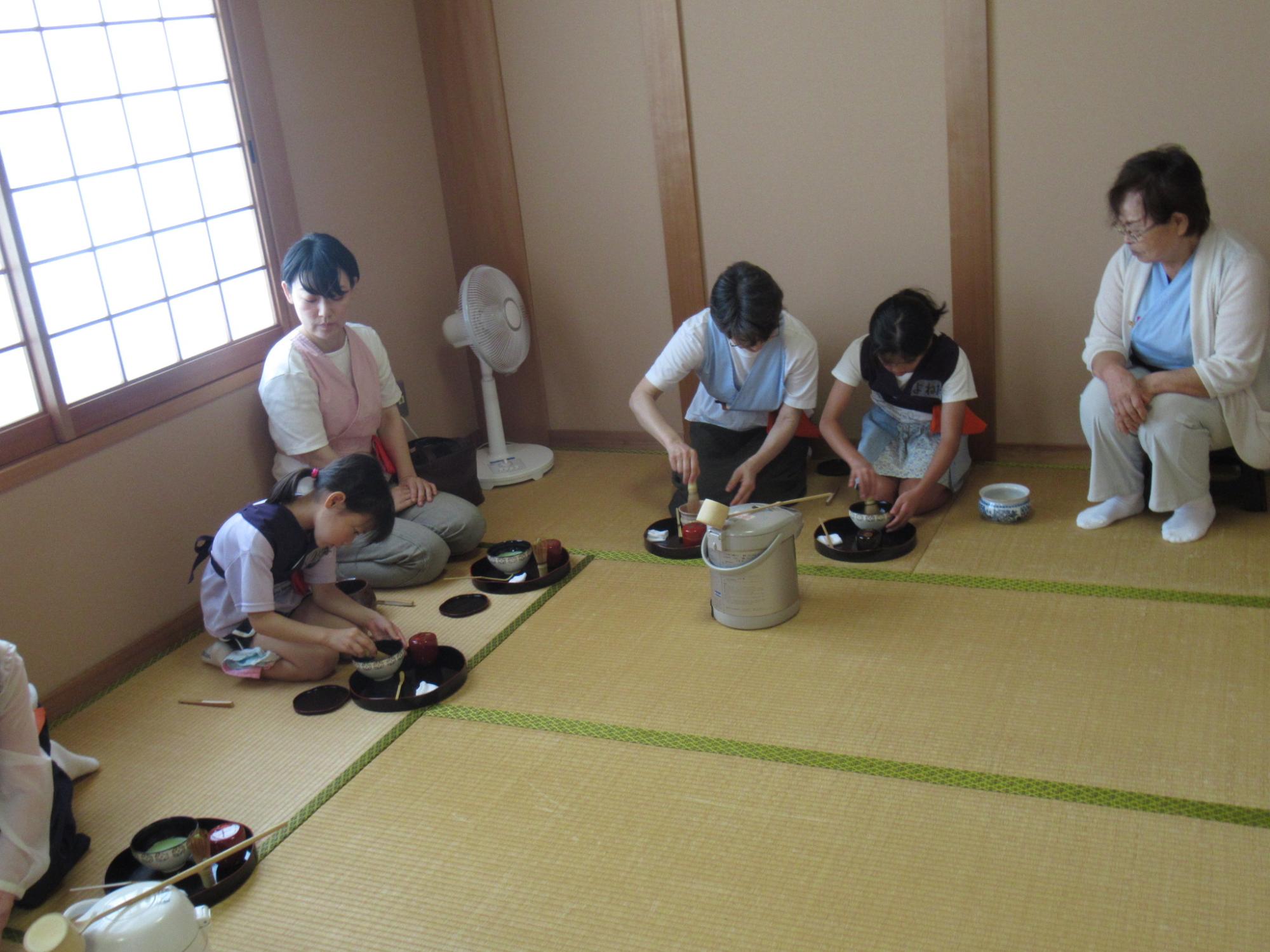 お茶立ての作法を教わる参加者たち