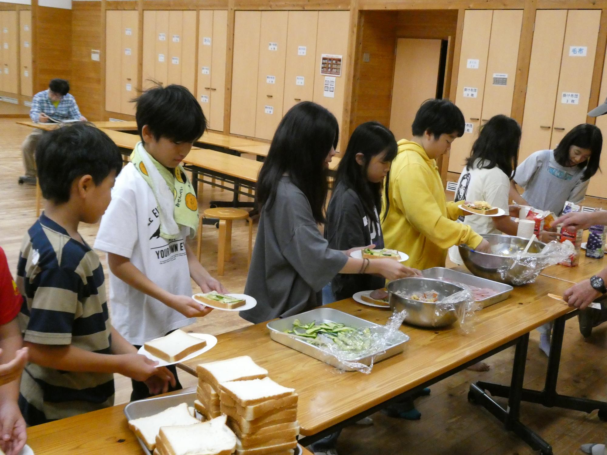 朝食のサンドイッチを自分たちで準備する参加者たち