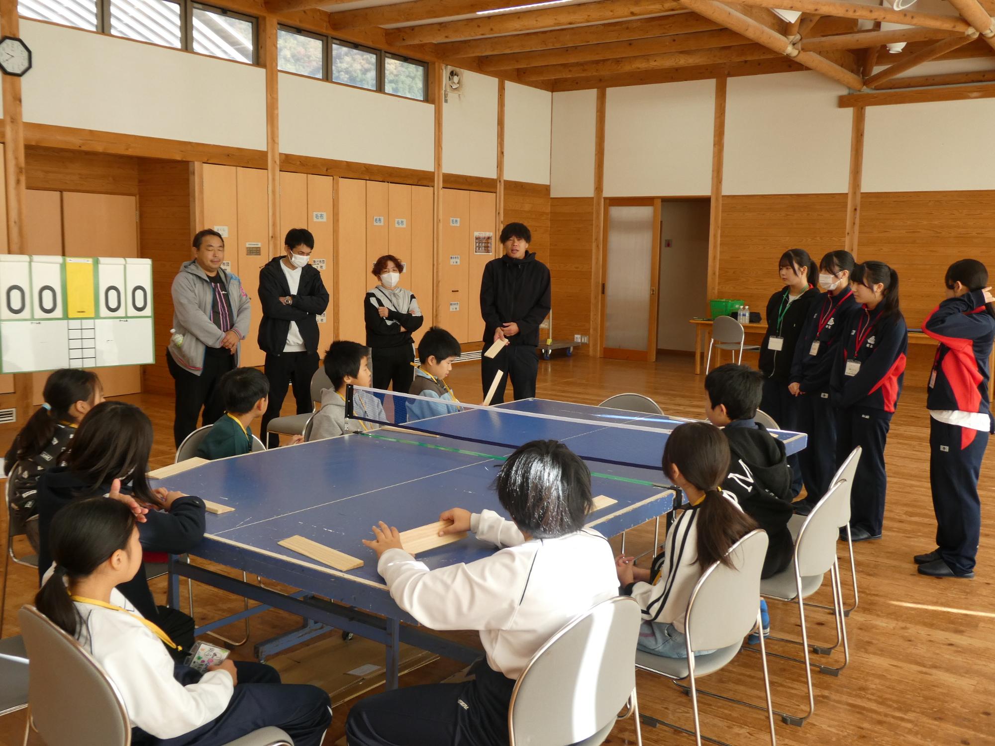 卓球バレーのルール説明を聞く参加者たち
