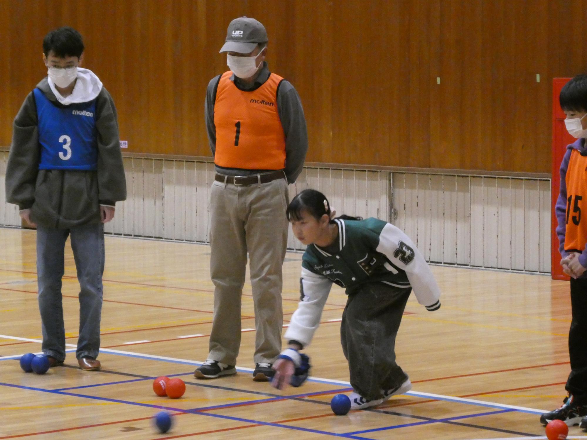 ボッチャ用のボールを投げて高得点を狙う参加者たち