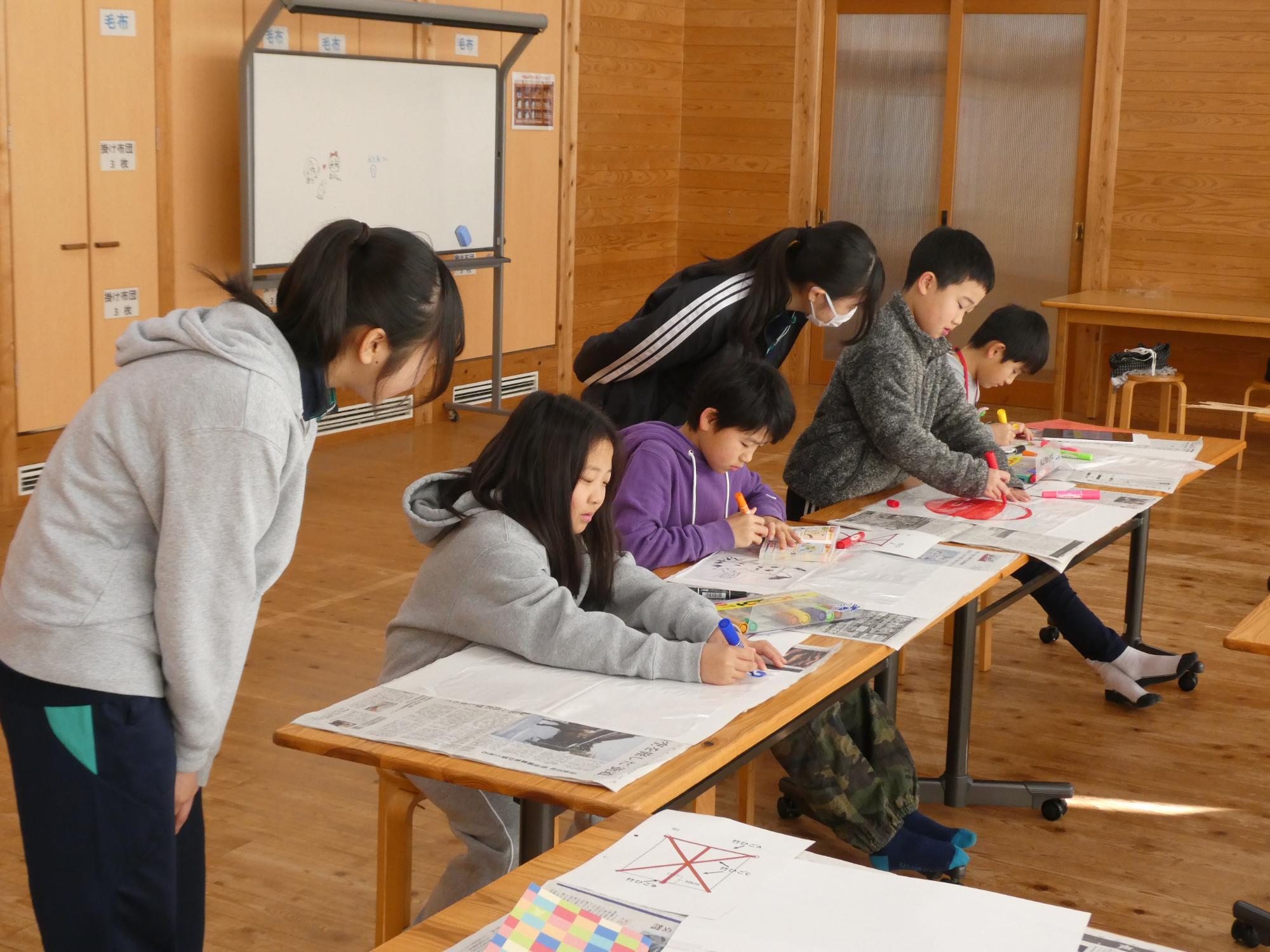 ビニール用紙に絵を描く参加者たち