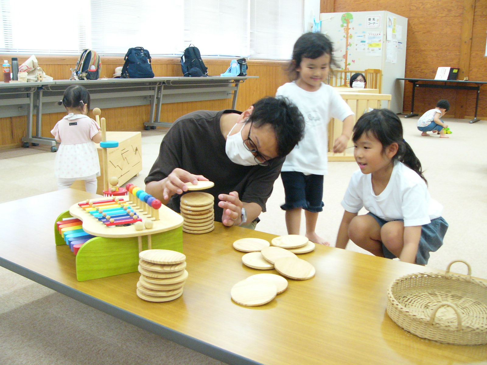 複数の参加親子が木製のおもちゃを使って遊んでいる写真