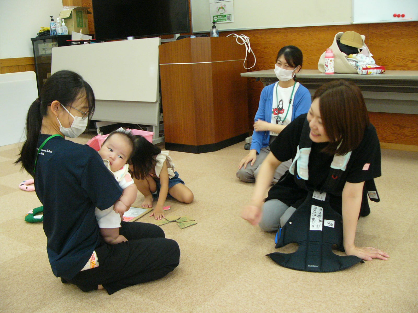 先生が赤ちゃんを抱っこしてあやしている写真