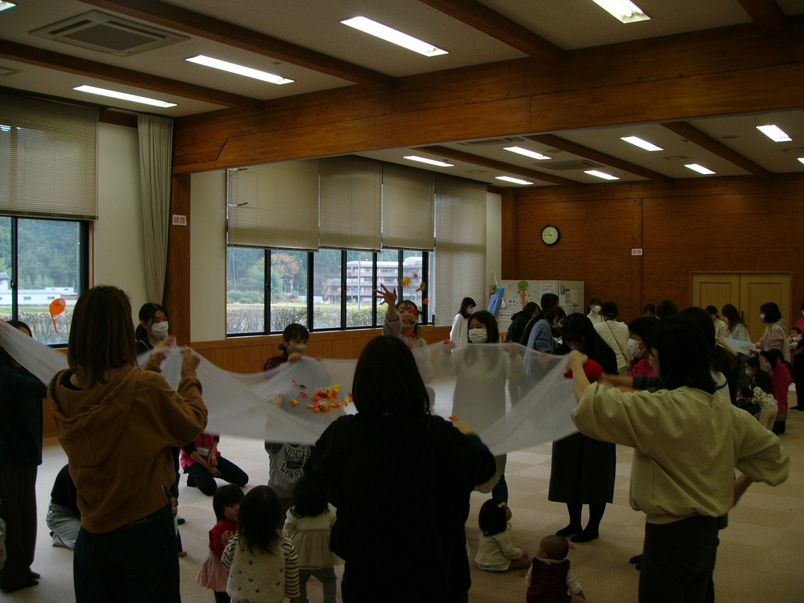 参加者親子が大きいストール布の上にボールを乗せて遊んでいる写真