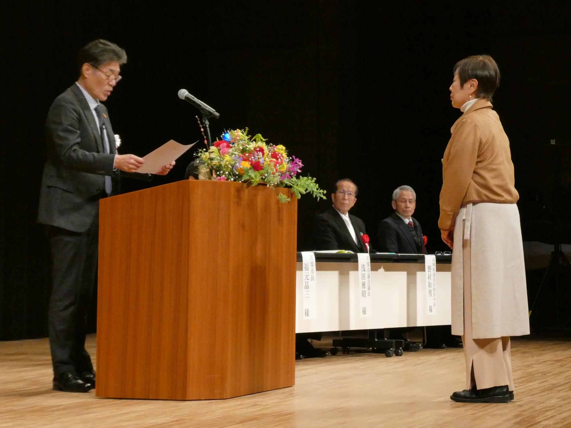 修了証書授与で代表者の学生が学園長より賞状を授与