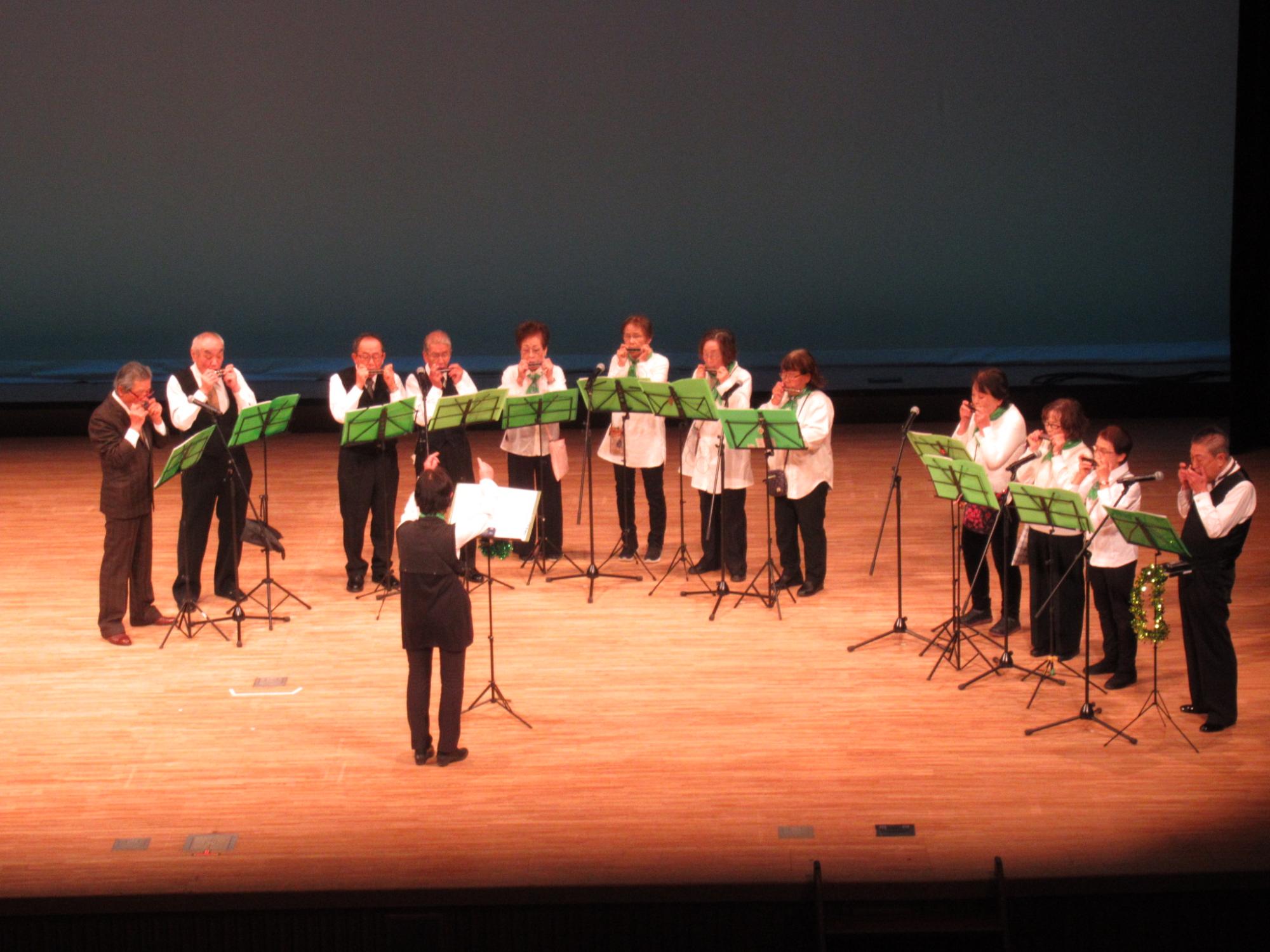 ハーモニカクラブの発表で演奏を披露しているみなさんの写真