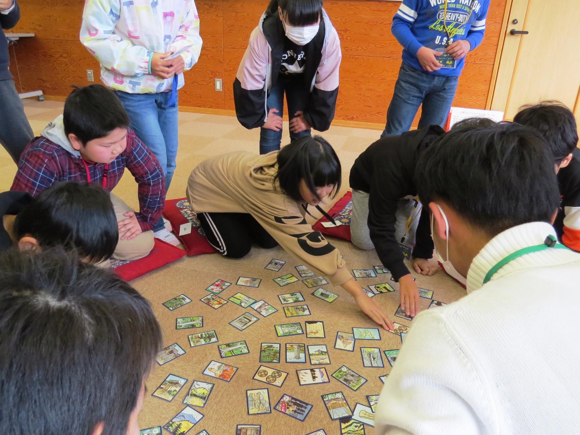 子ども達が円になってかるたを取り合っている写真