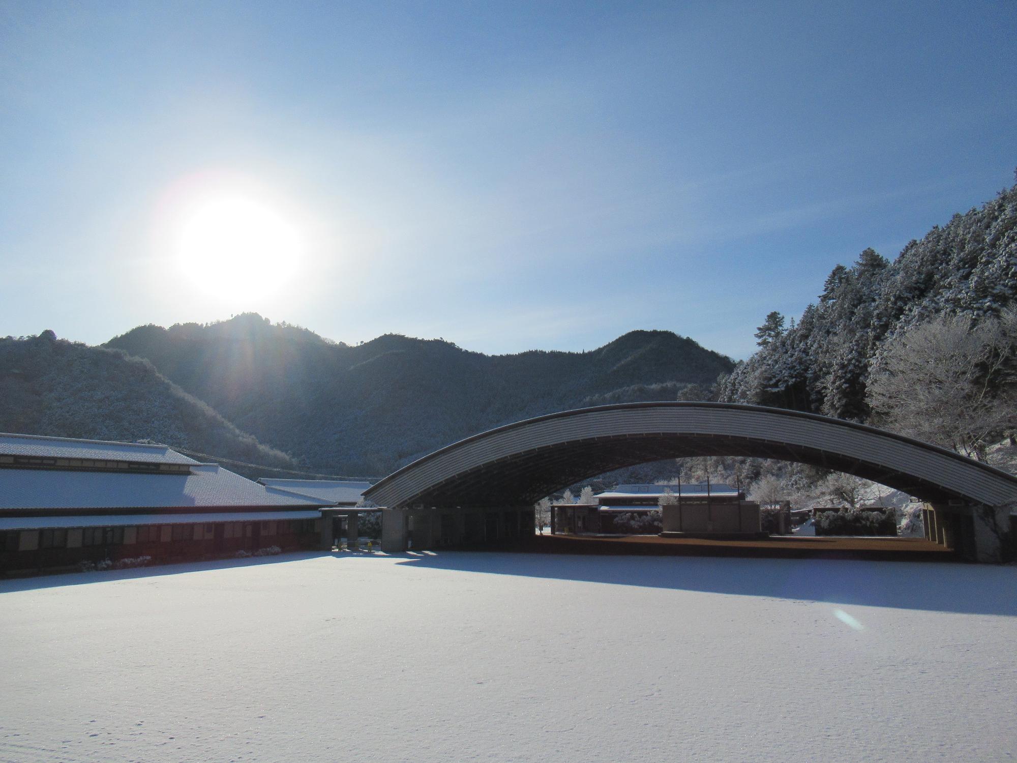 学遊館の雪景色と輝く朝日の写真
