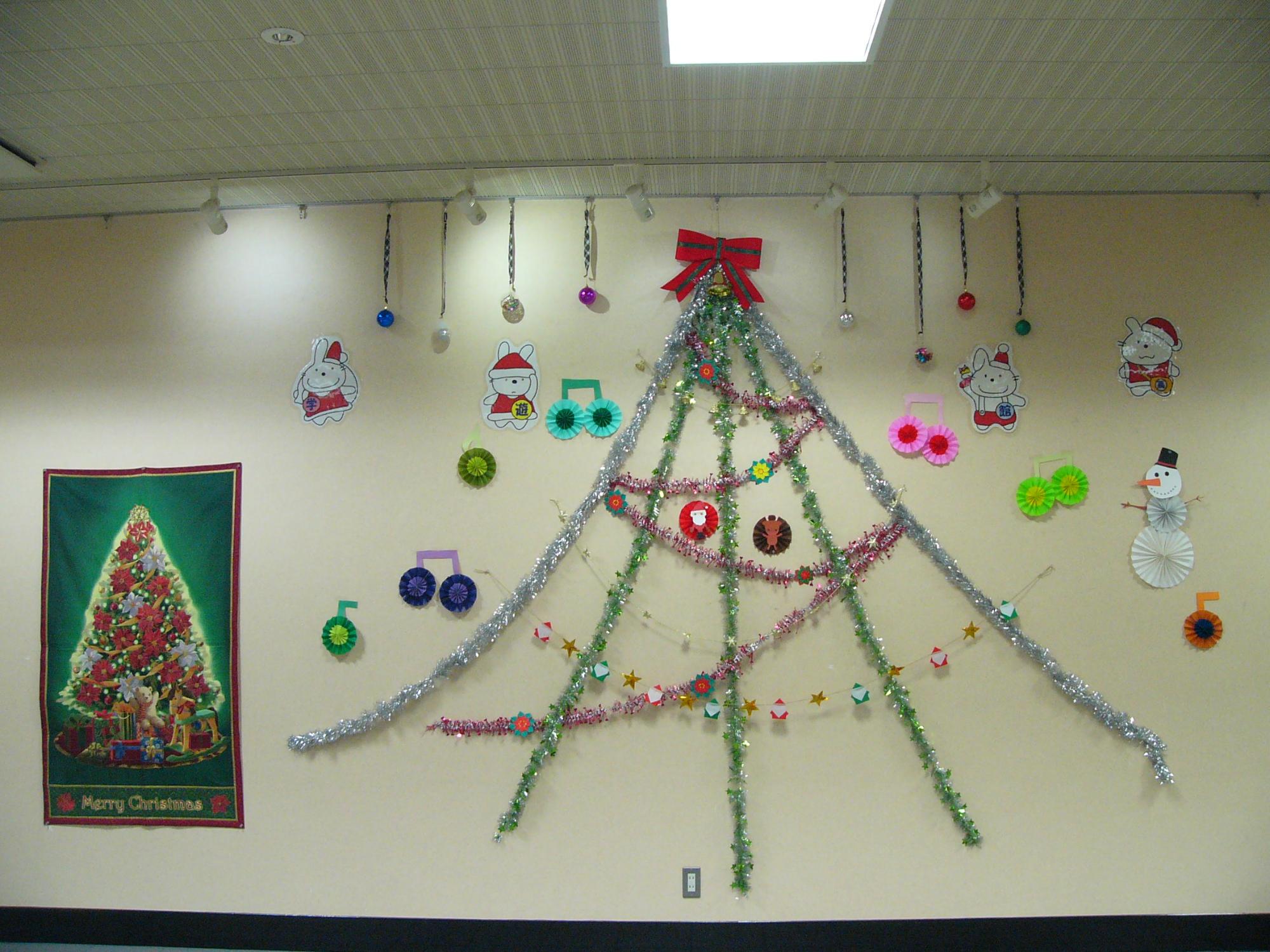学遊館ロビー展示で、壁いっぱいにクリスマス飾りをしている写真