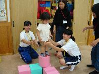山崎東中学校トライやるウィ―クで小さな子どもがバランスの取りにくいクッションの上に立つ写真