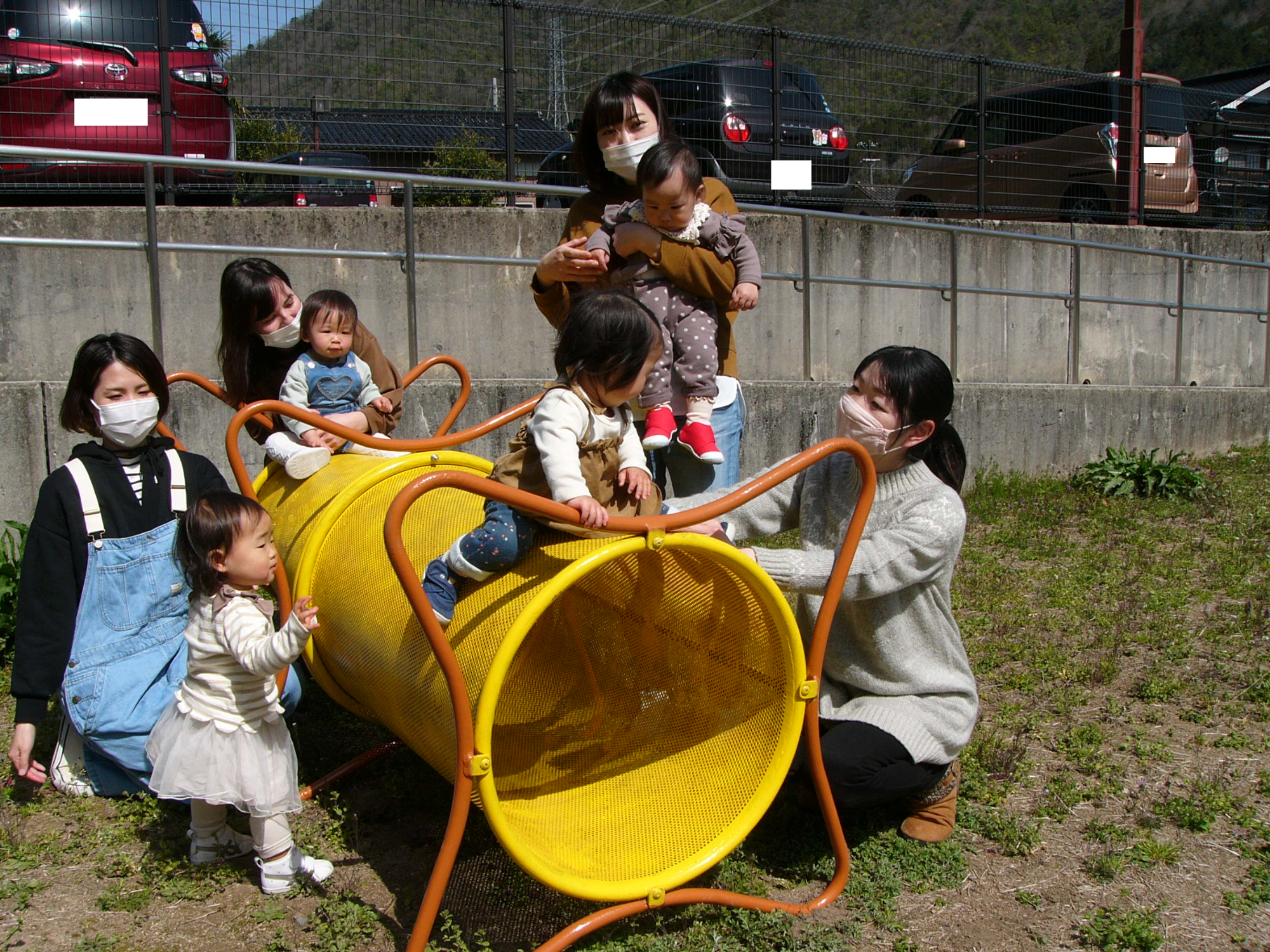 学遊館グランドの原っぱの遊具で遊ぶ子どもたちの写真