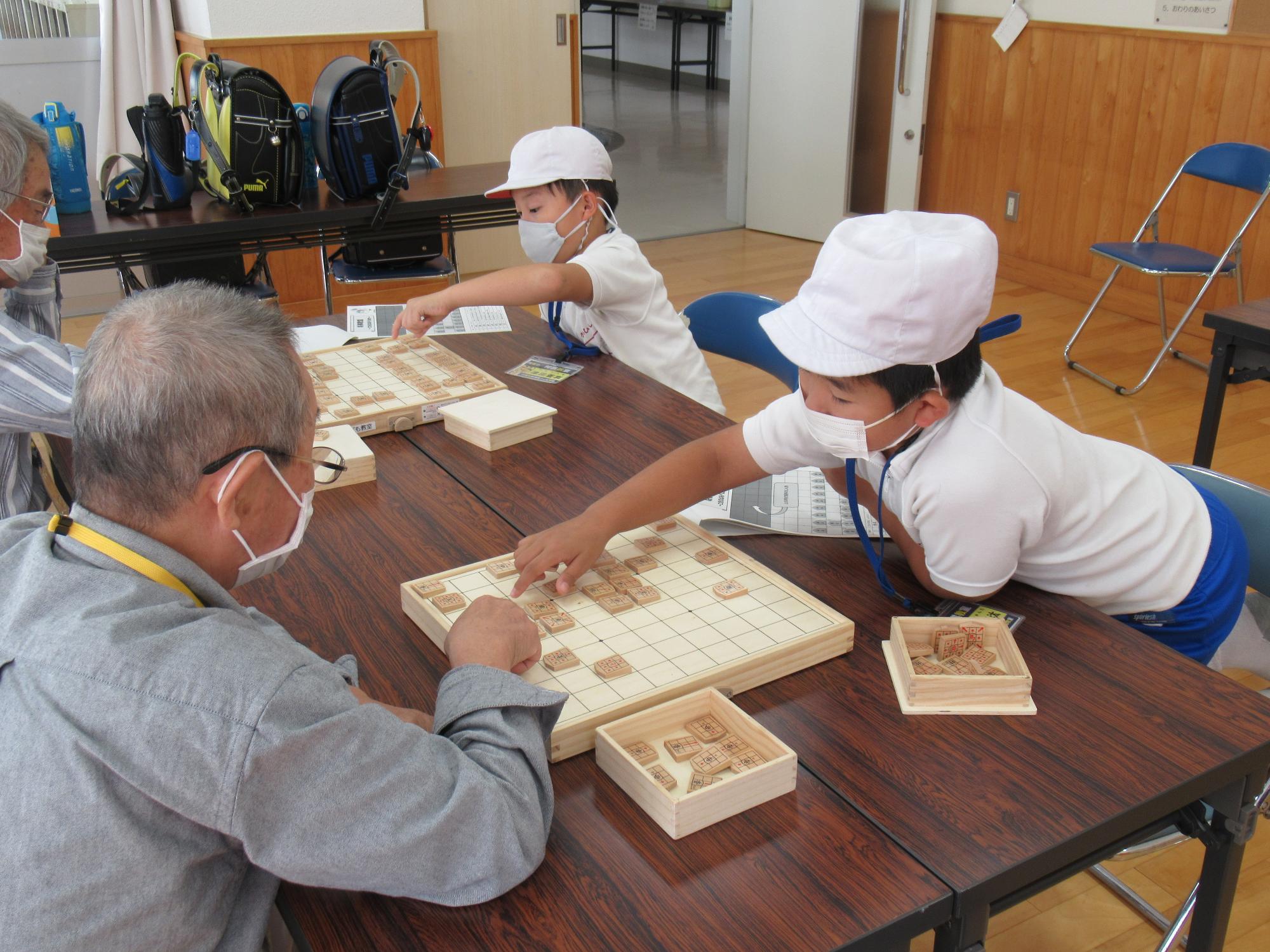 ボランティアさんのご指導のもと真剣に将棋をしている子ども達の写真