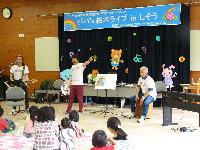 子育て絵本ライブコンサートで楽器を演奏をする人たちと子どもたちの写真