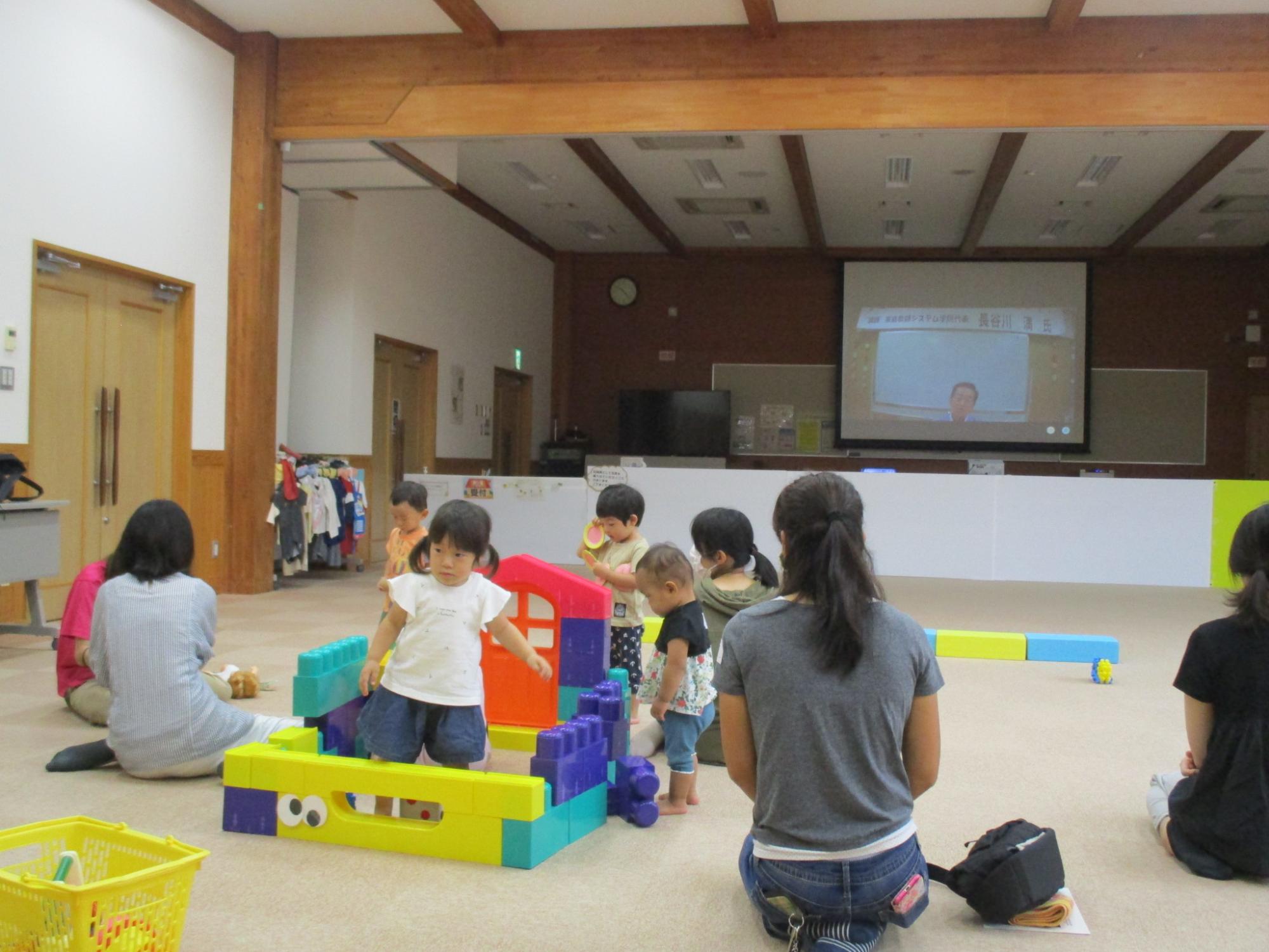 学遊館研修室でリモート会議で講演をきいている親子らの写真