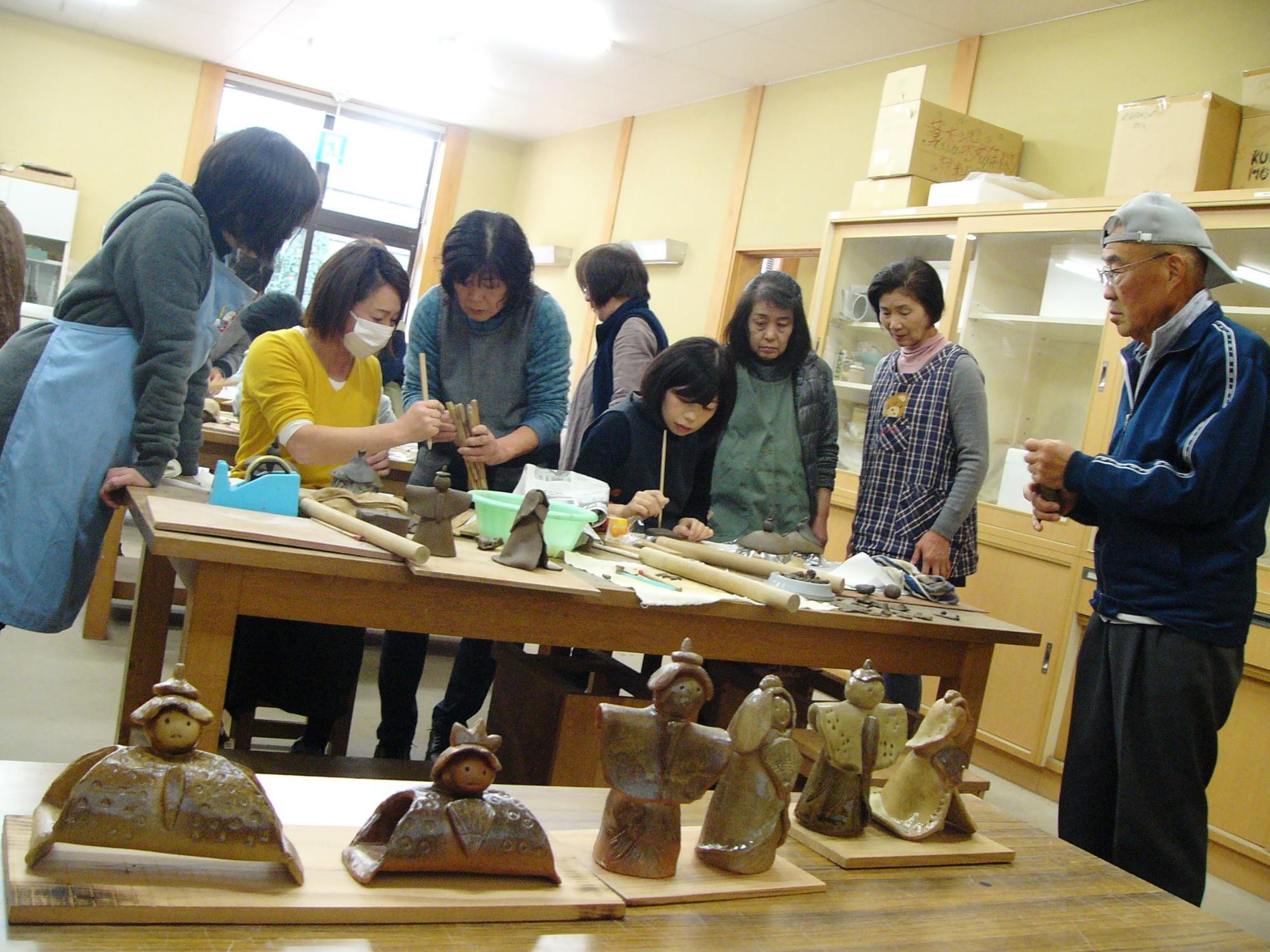 作品の見本を見ながら、陶芸づくりを楽しんでいる陶芸教室参加者らの写真