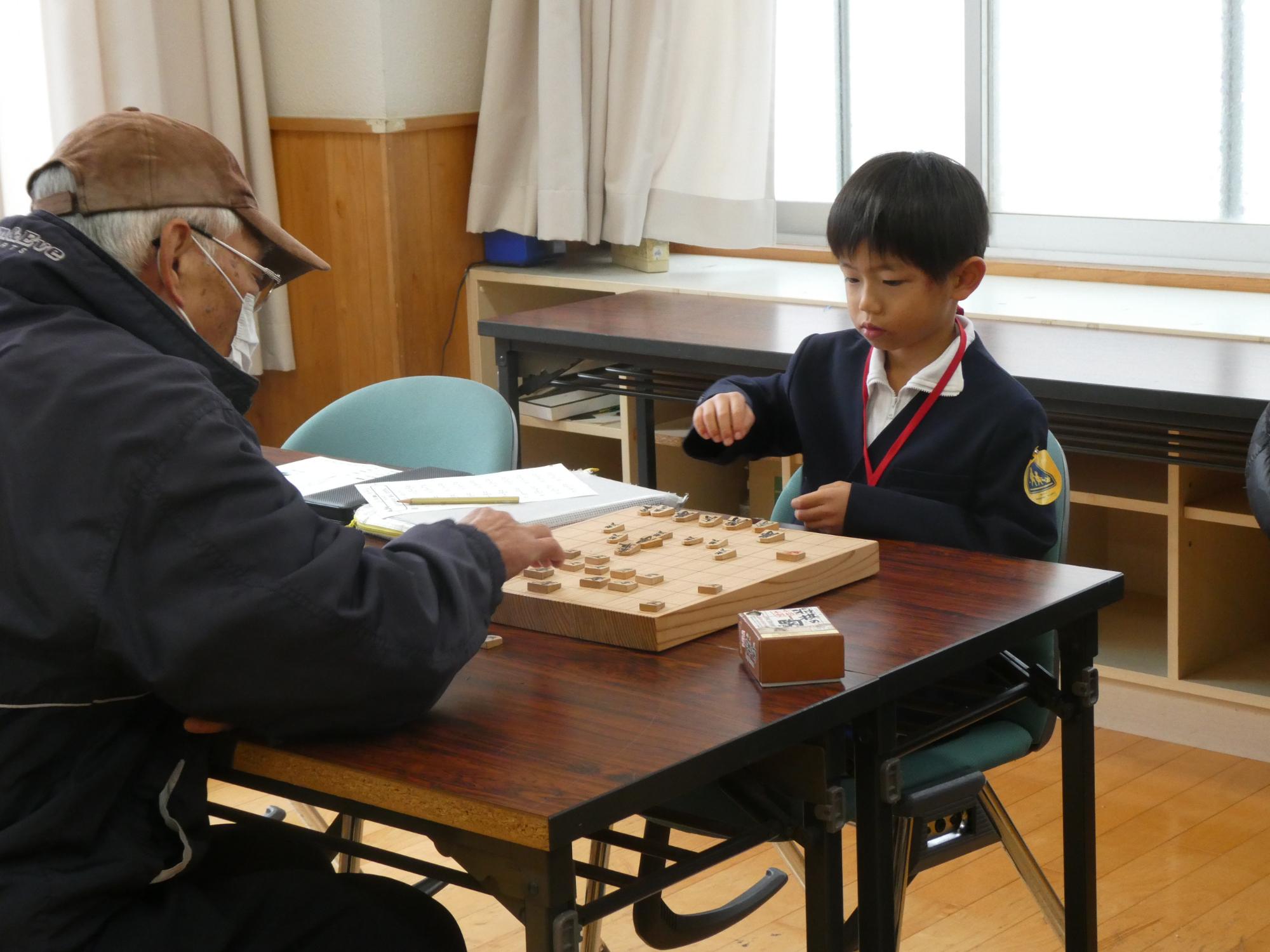 サポーターと対局する子どもの写真