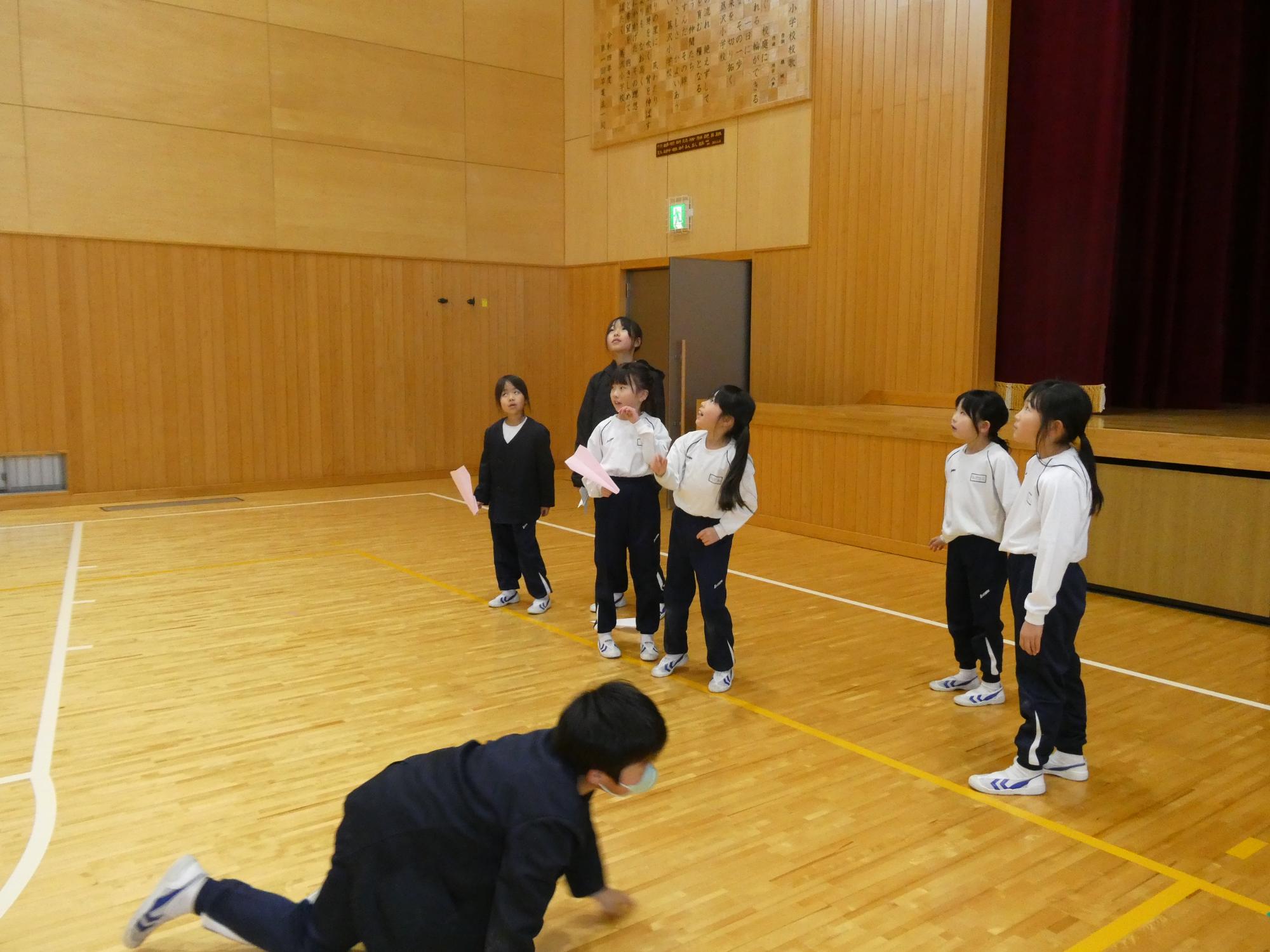 紙飛行機を飛ばす子どもたち