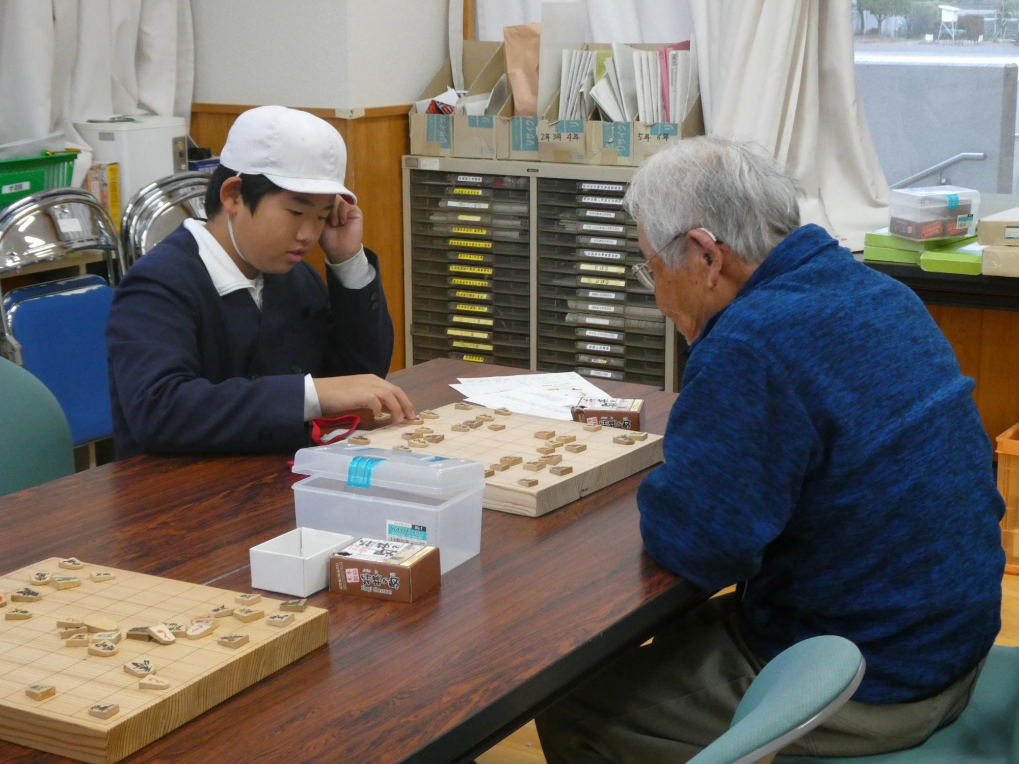 熱心な様子でサポーターと対局する子ども