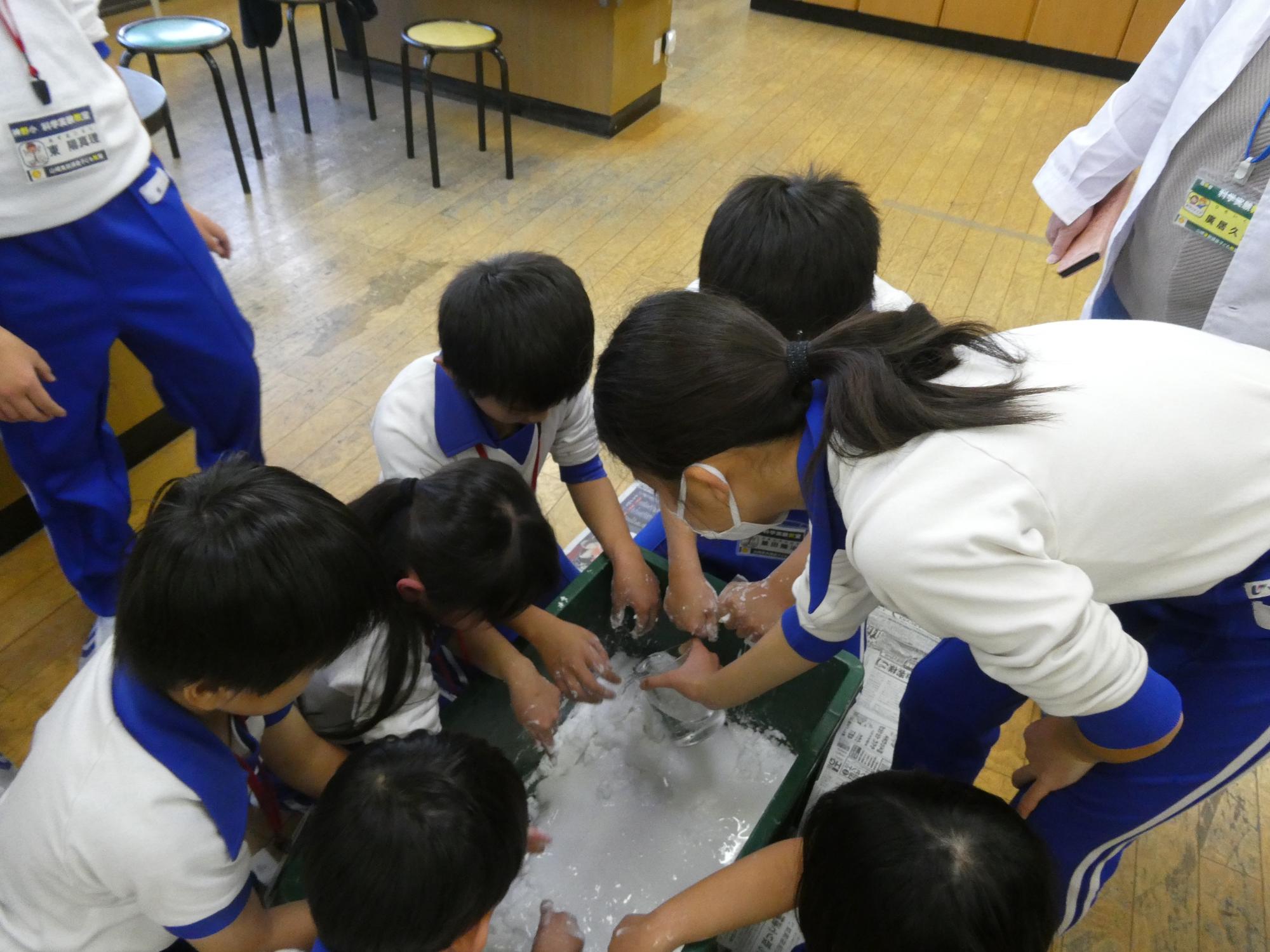 片栗粉10キロ分のダイラタンシーを作る子どもの写真