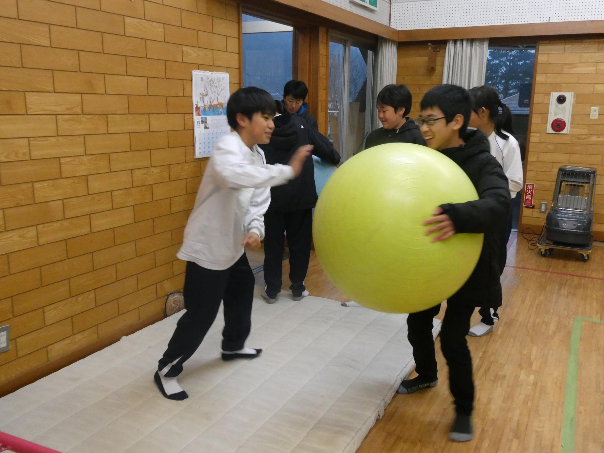 大きなボールで遊んでいる子どもの写真