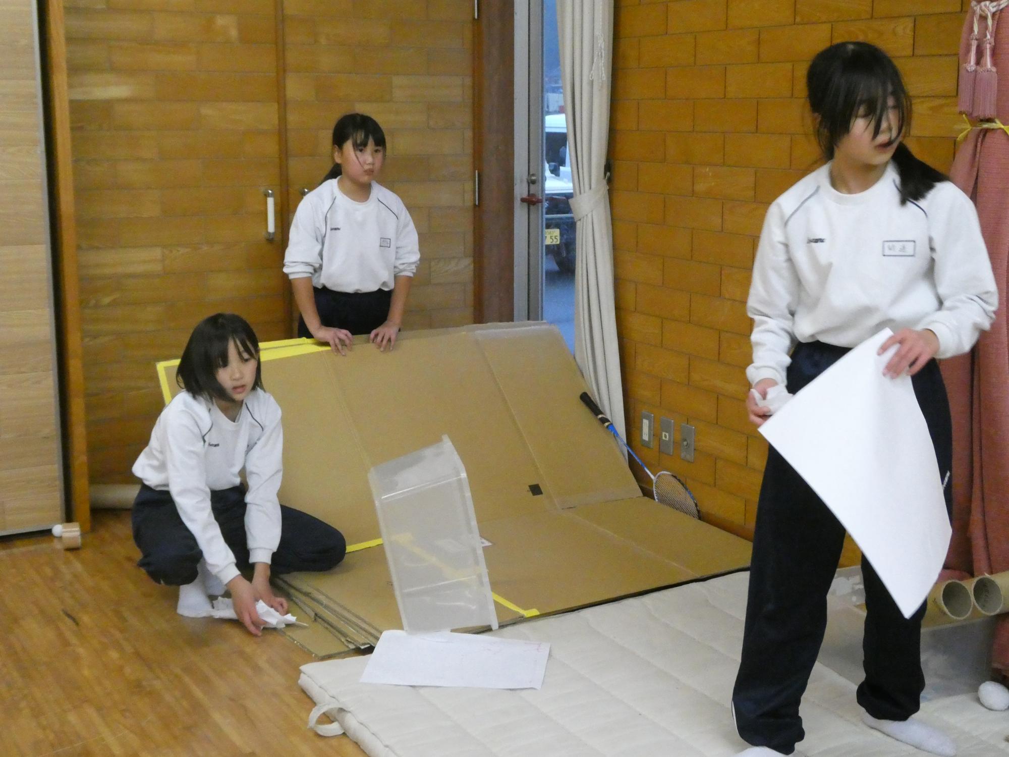 段ボールを使って自由遊びをする子どもの写真