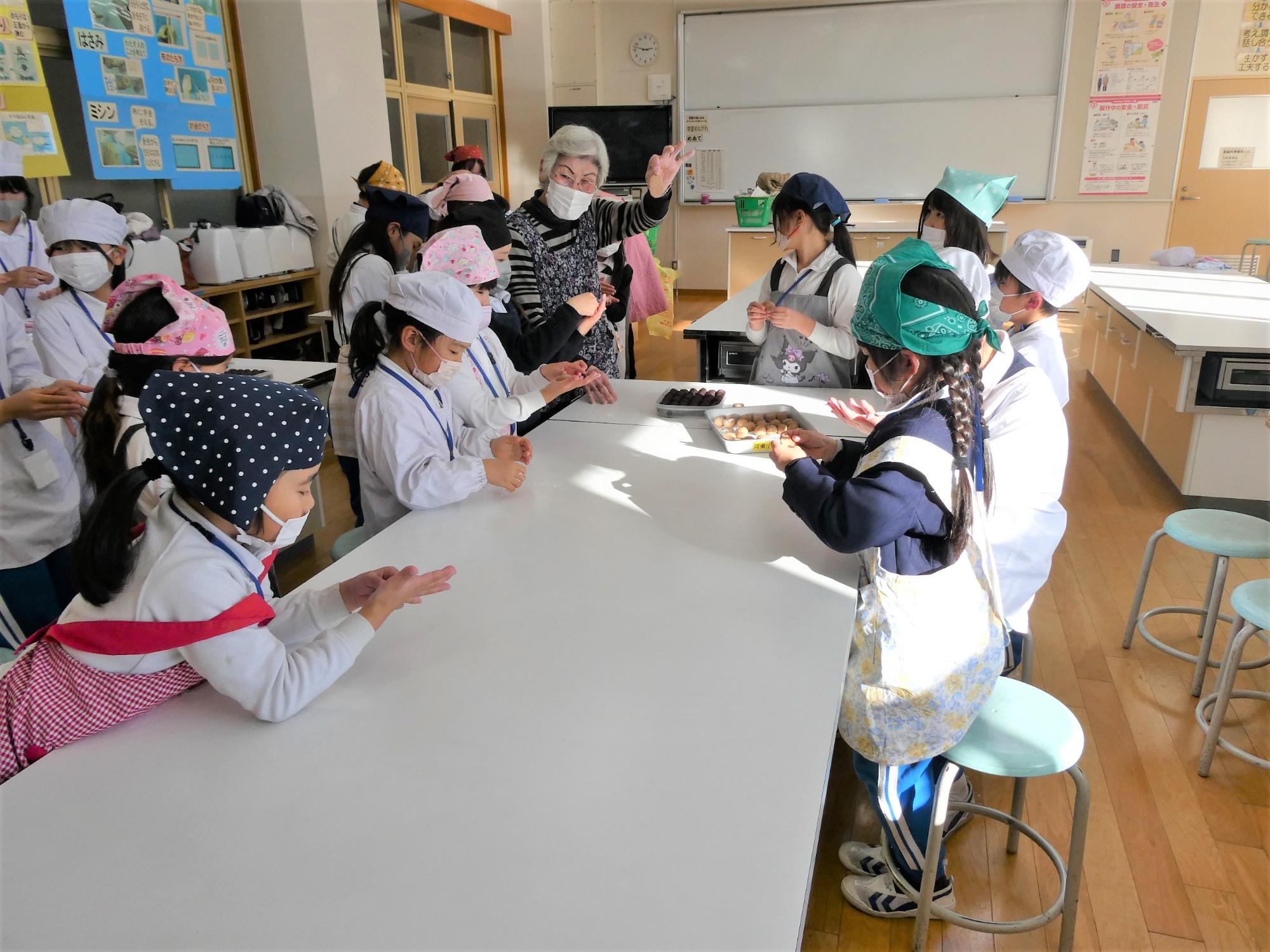 講師と一緒にあんこを包む子どもたち