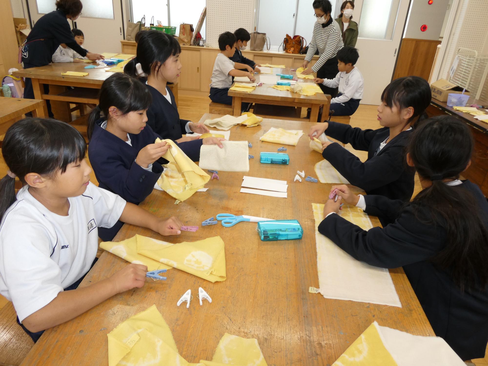 染めた布を重ねる子どもたち