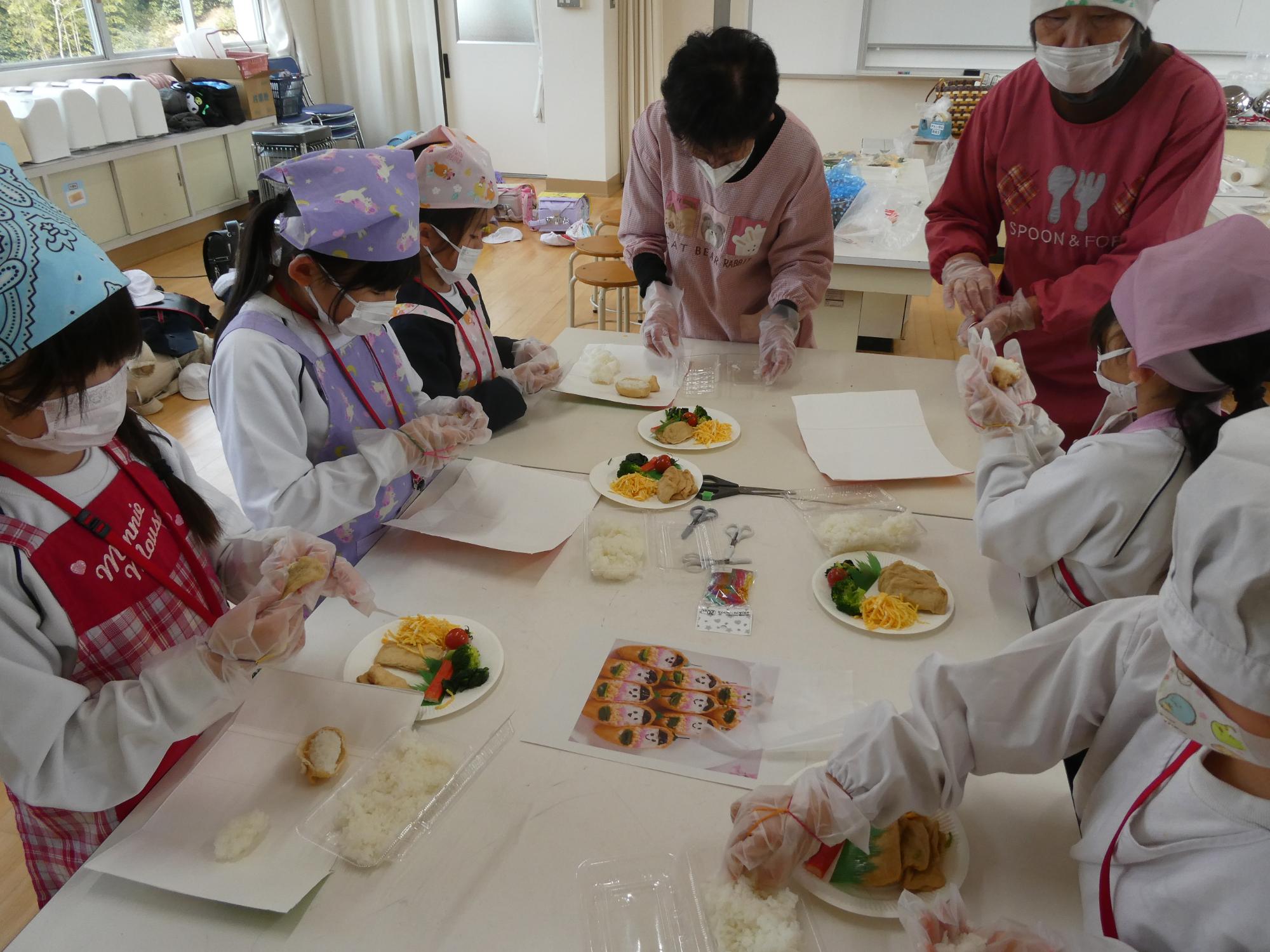揚げにご飯を詰める子どもたち