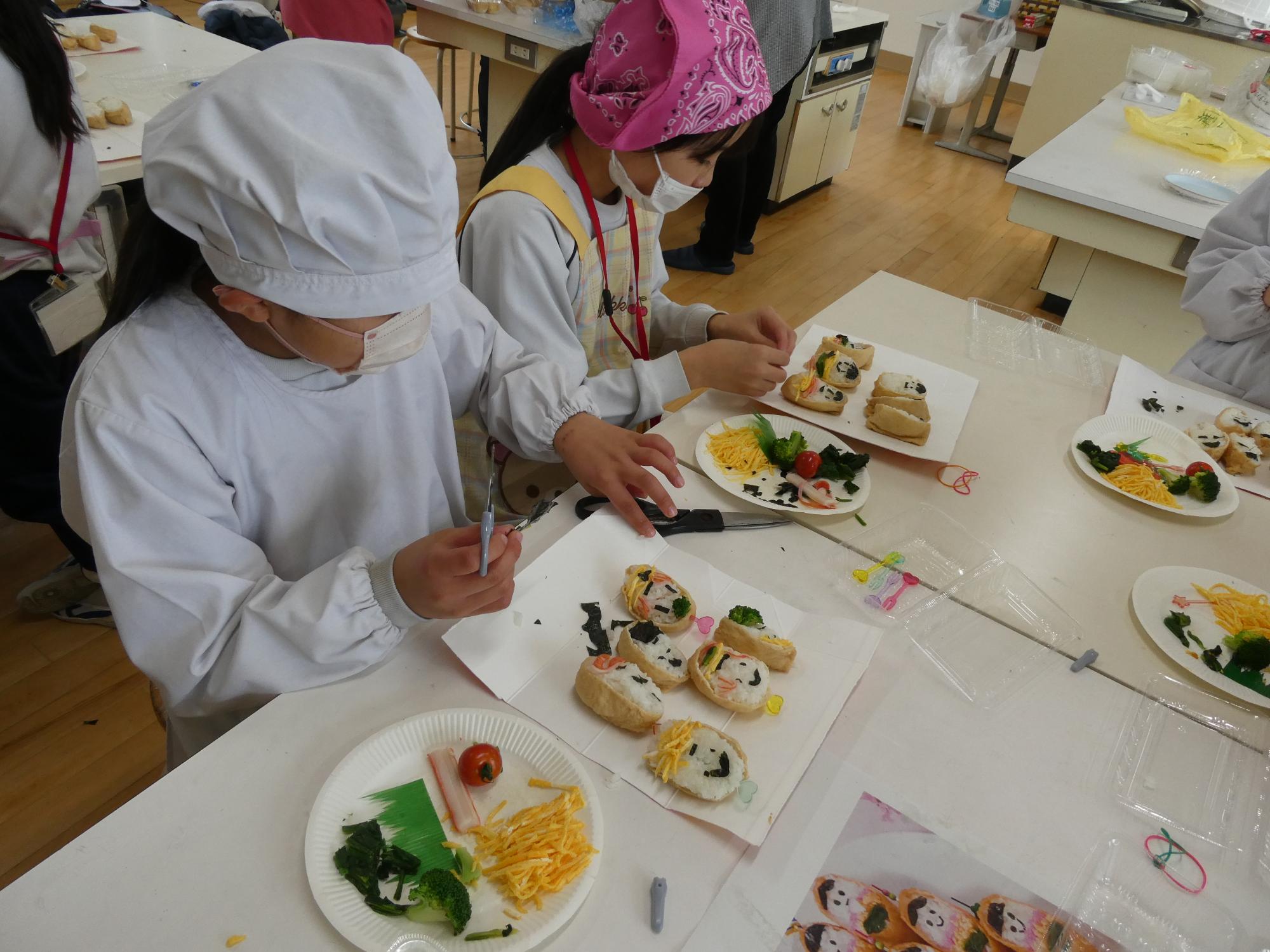 海苔を切って顔をデコレーションする子どもたち