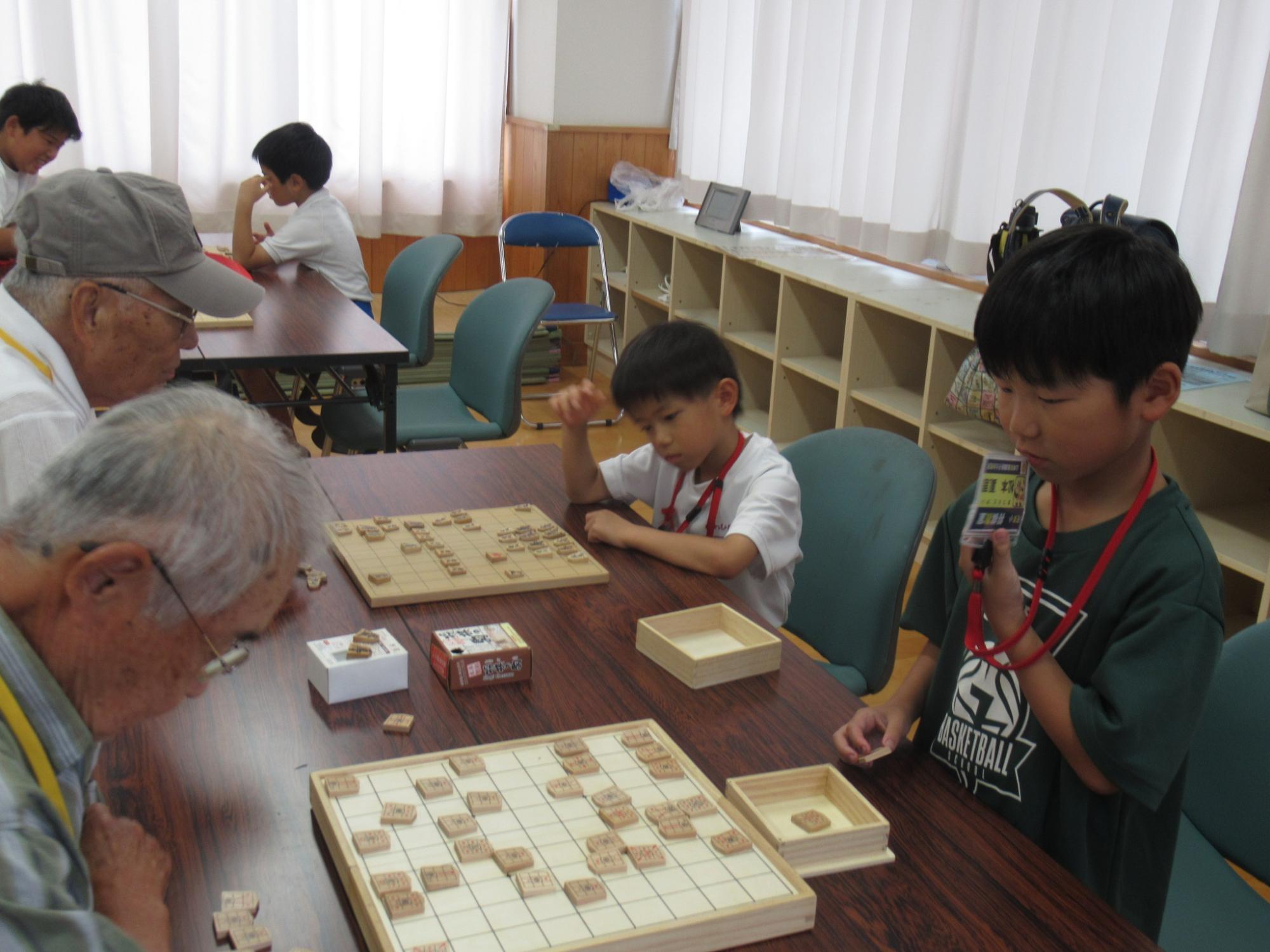真剣に対局する子どもとボランディア講師