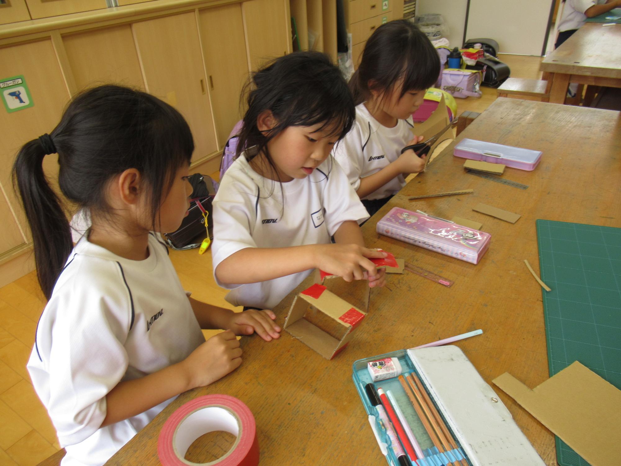段ボールを組み立てる子どもたち