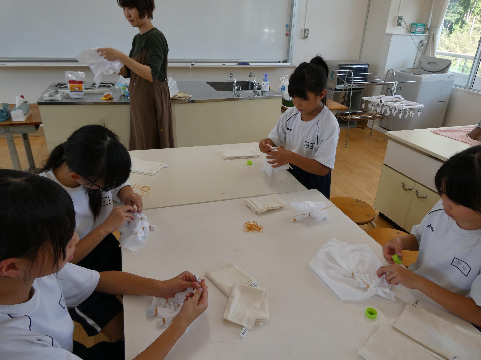 ビー玉を生地にしばりつけていり子どもたち