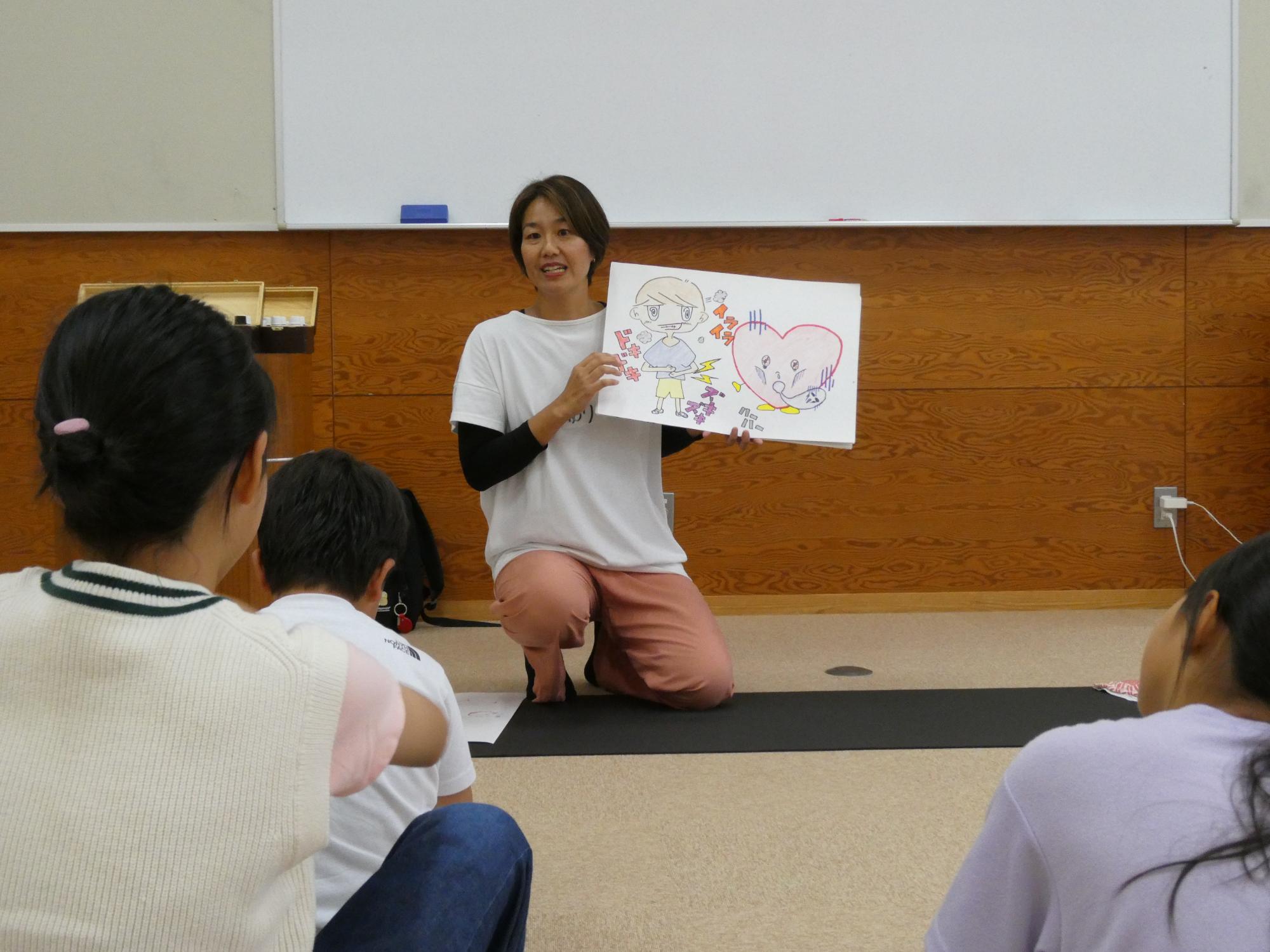 アロマテラピーについて紙しばいで説明する講師