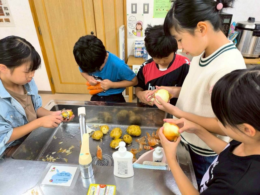 カレーに入れるジャガイモをむく子どもたち