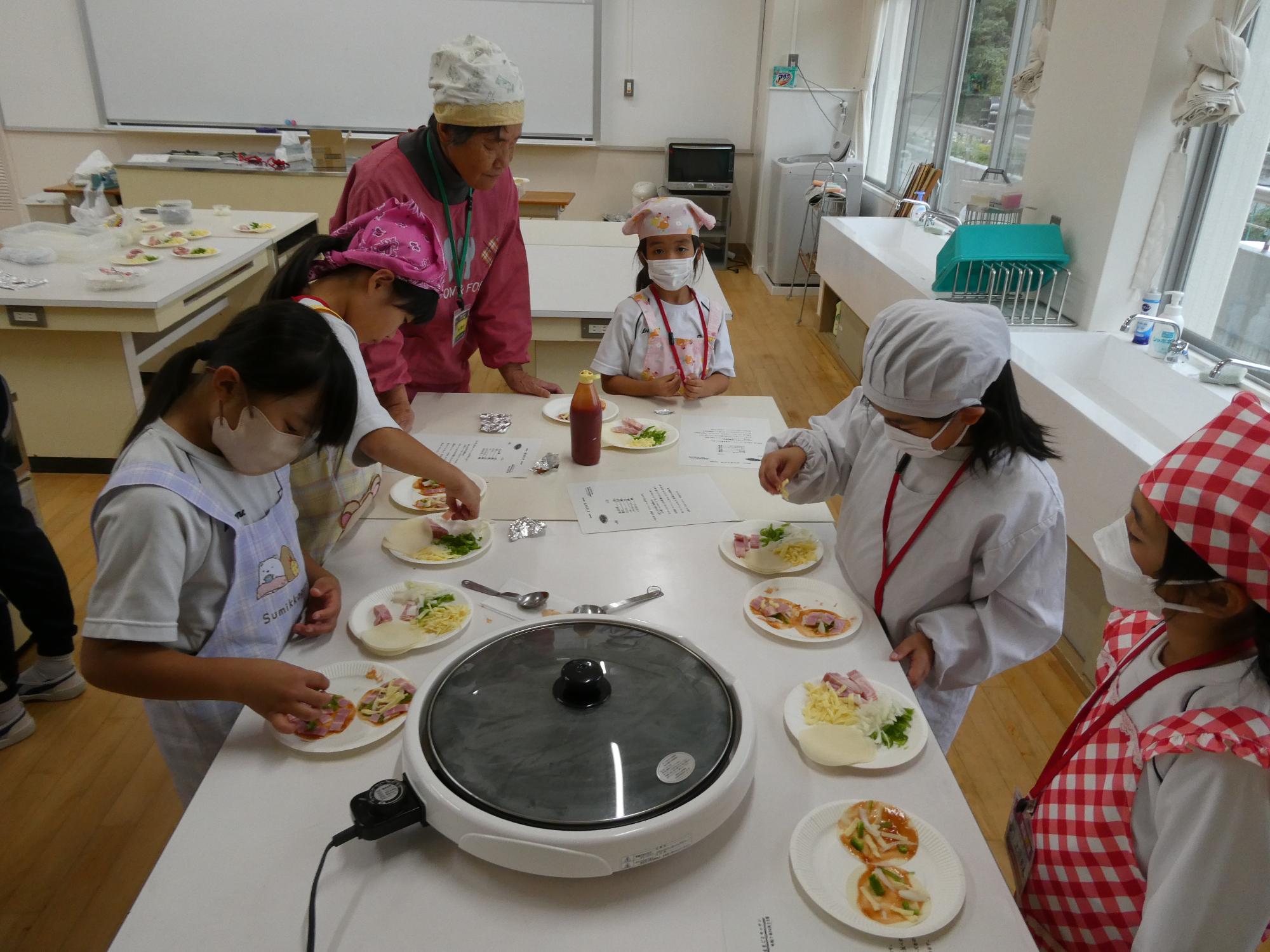 餃子の皮に具をトッピングする子どもたち