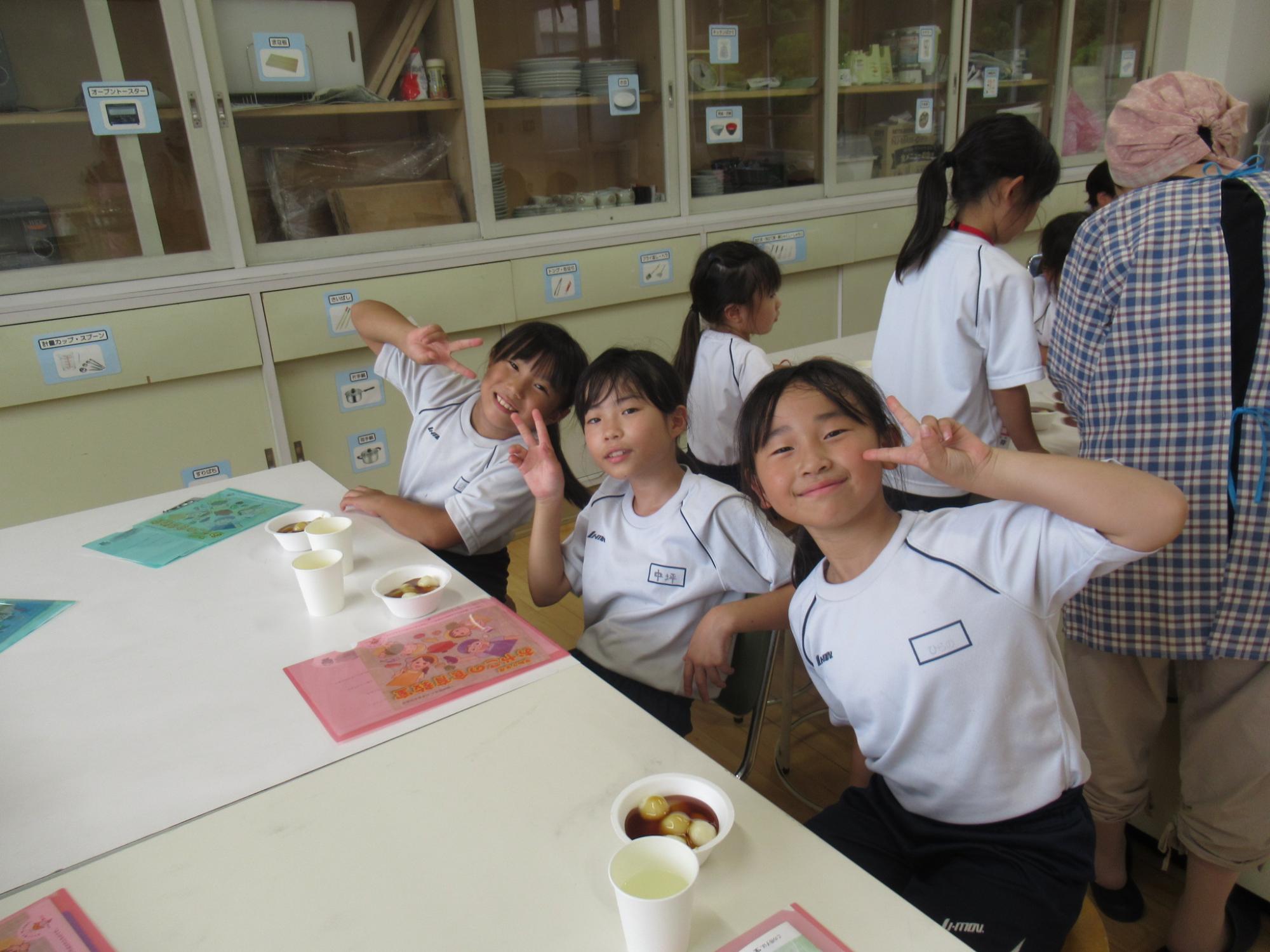 できあがった白玉団子を前にピースサインをする子どもたち