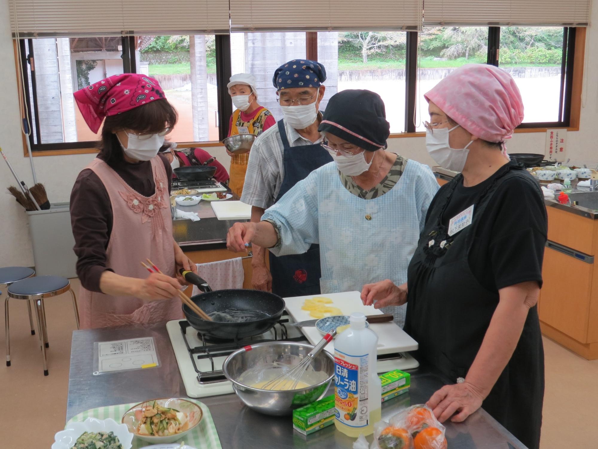 料理講座で料理をする講師の先生と生徒のみなさんの写真