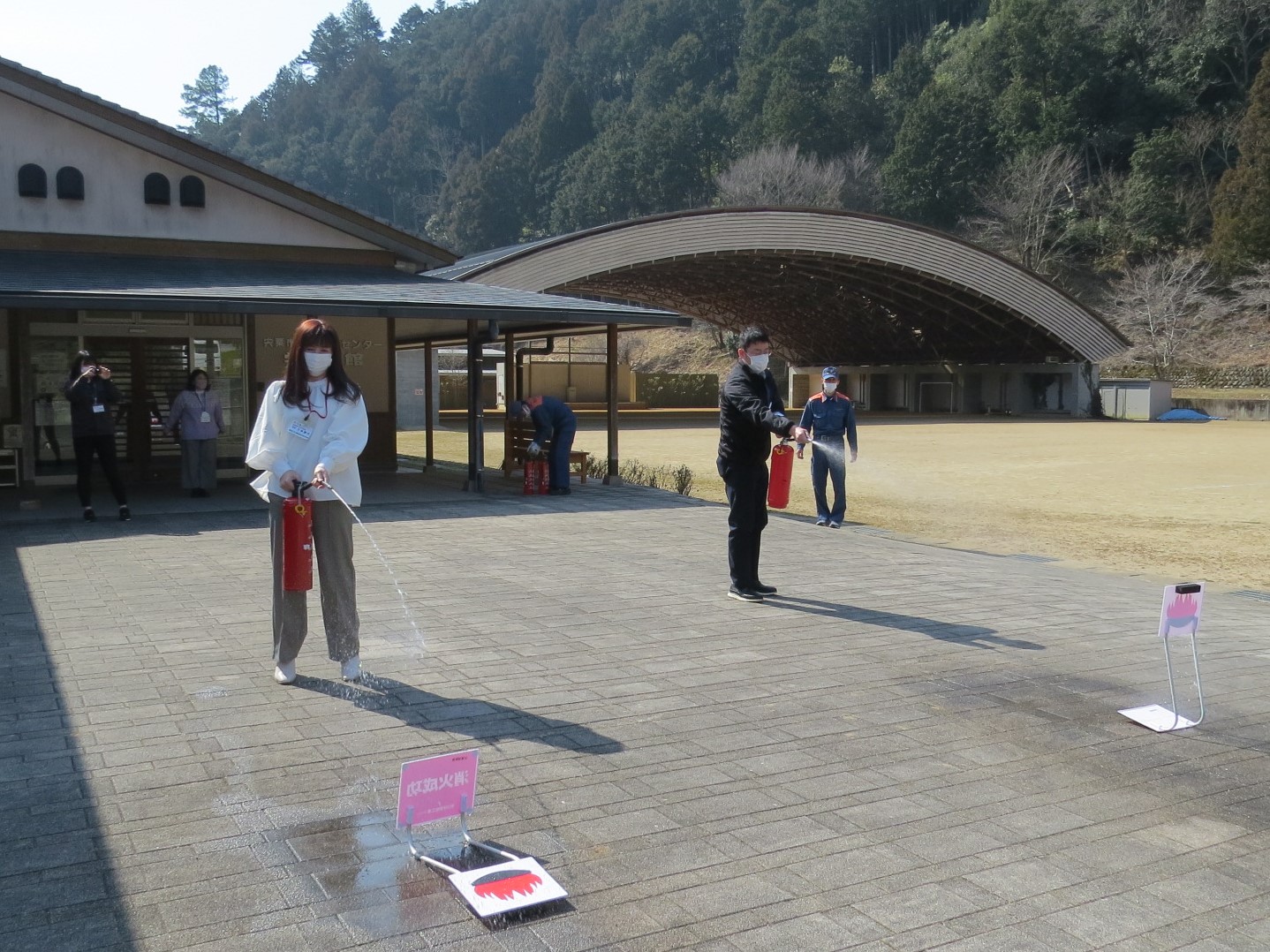 消防訓練で、初期消火を想定して消火器で放水している写真