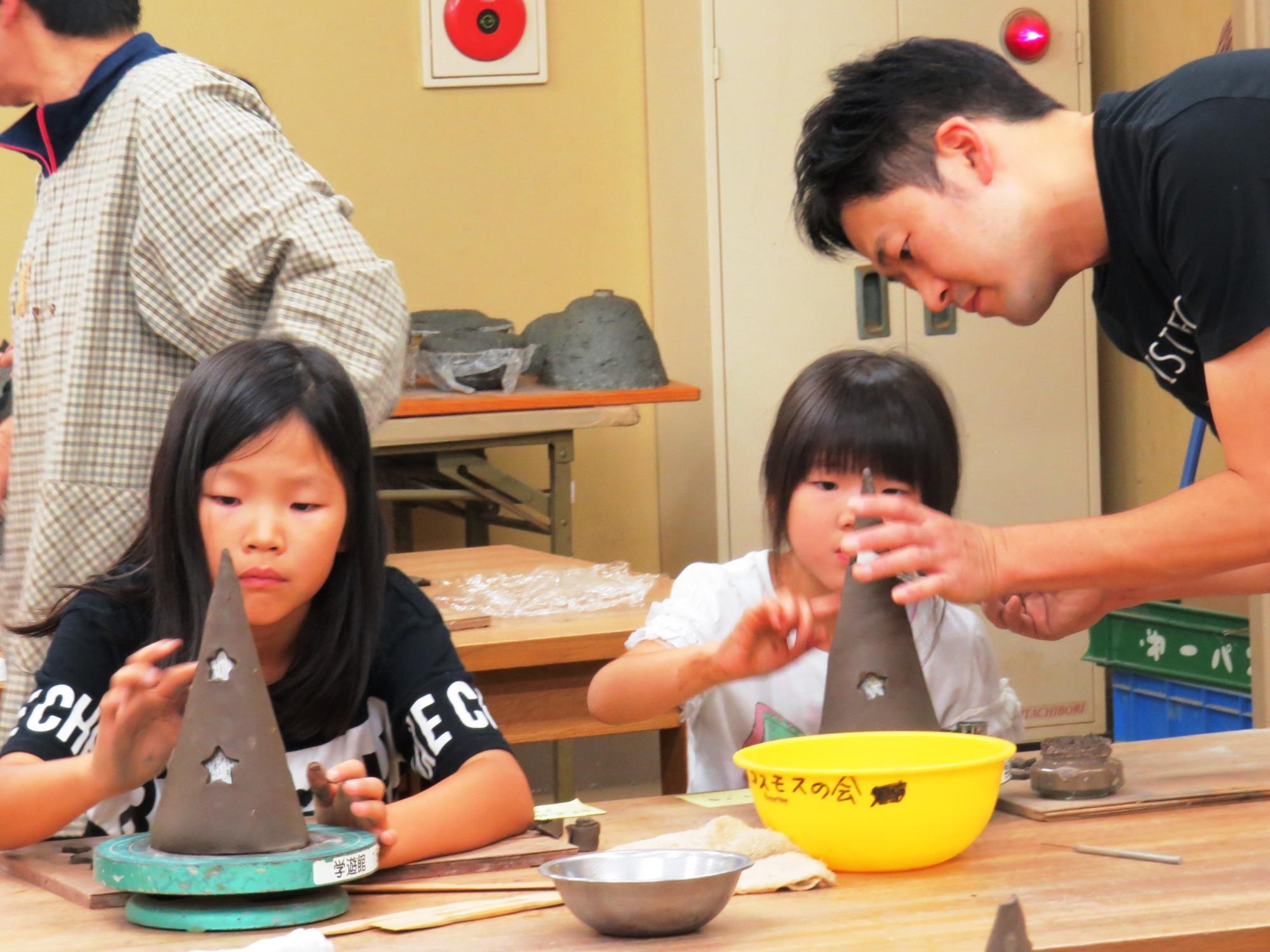 子どもたちがキャンドルと受け皿づくりを体験している写真