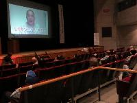交通安全教室で学生らが席に座りDVDを視聴している写真