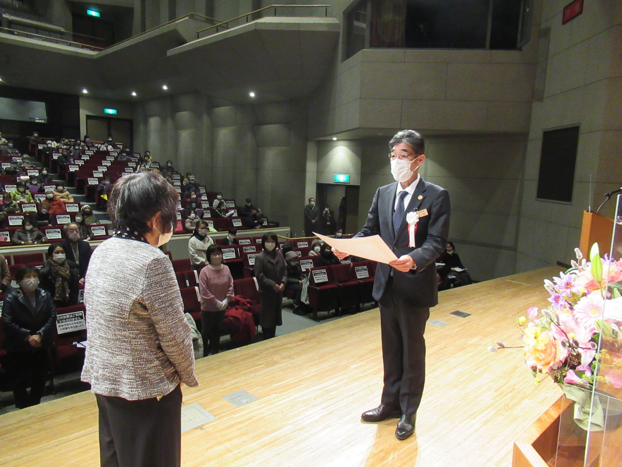 閉講式で宍粟市教育長から修了生を代表して修了証書を受けとる学生の写真